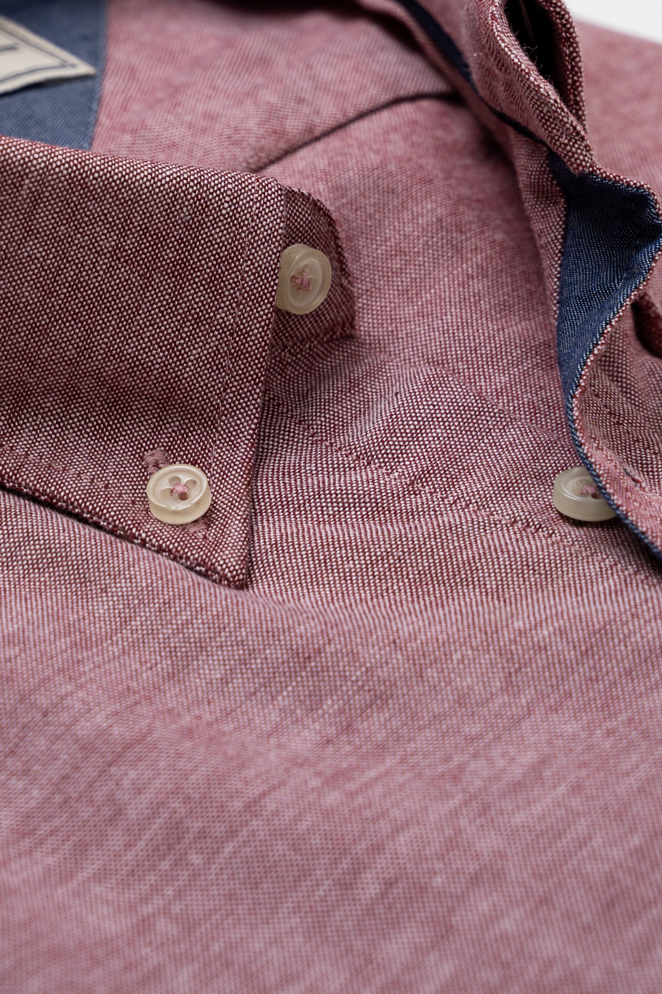 Dark red shirt fabric close-up with button cuffs and front buttons