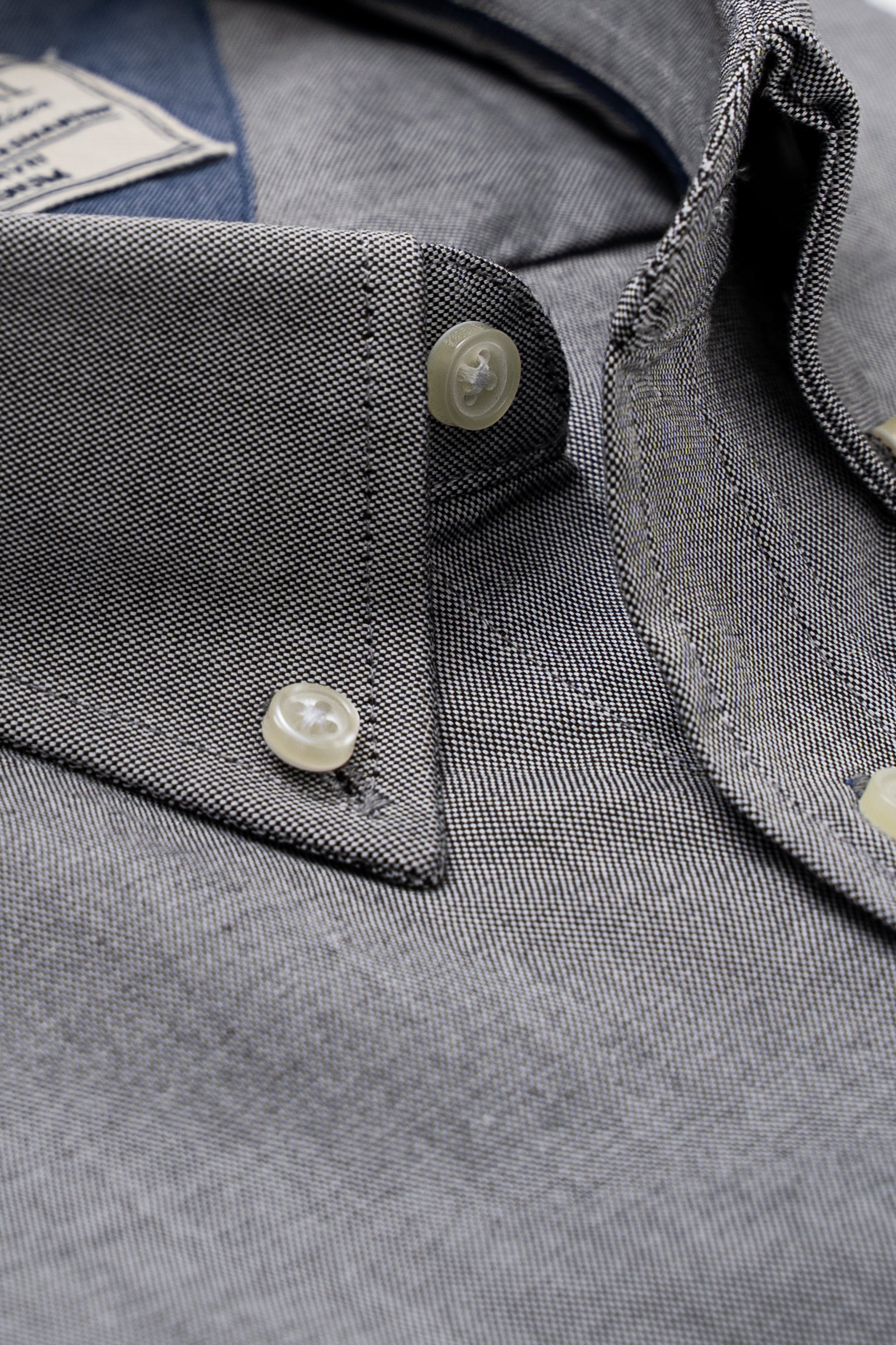 Mid grey dress shirt close-up of buttons, pointed collar, and shirt placket