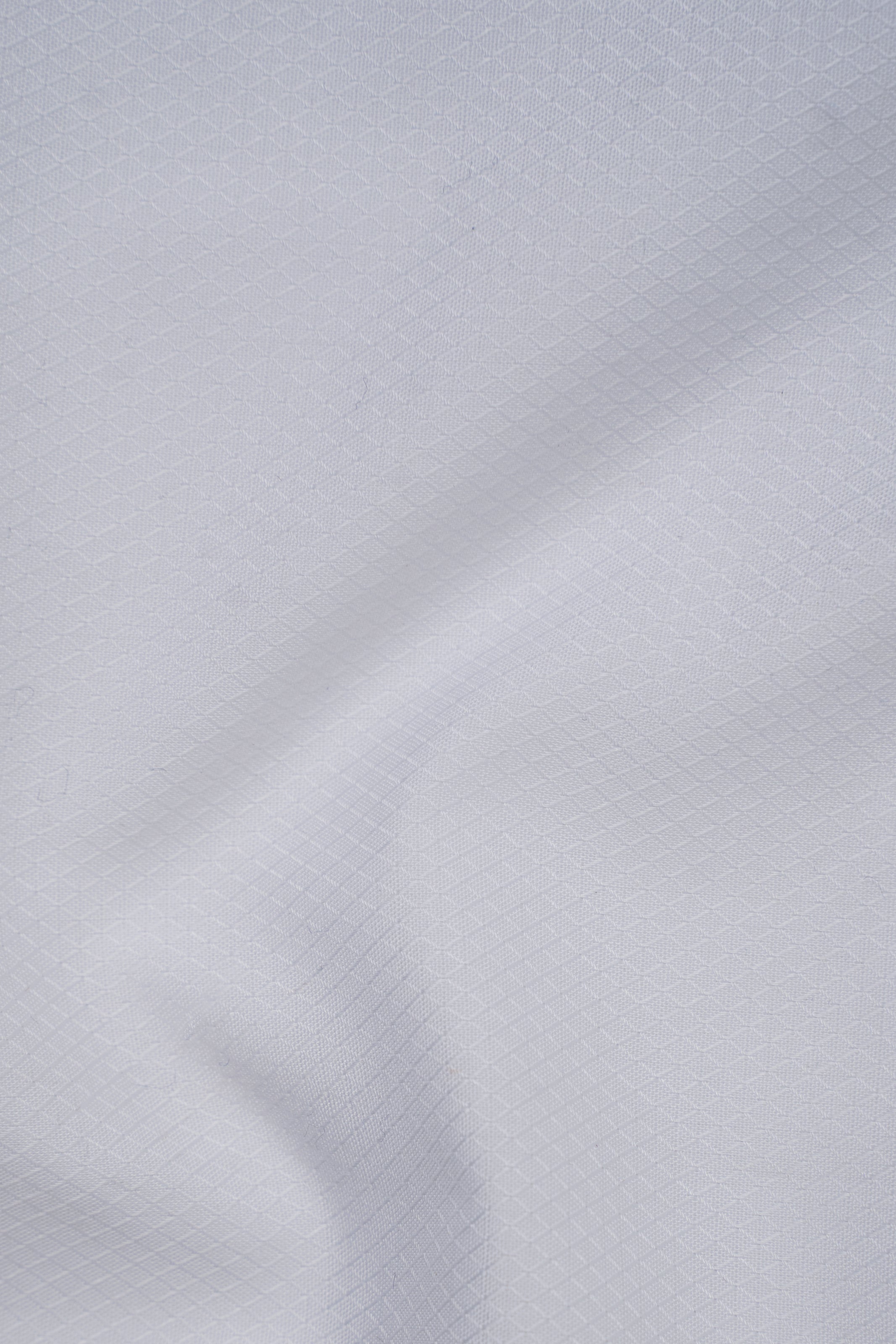 Light textured white shirt fabric close-up with subtle pattern