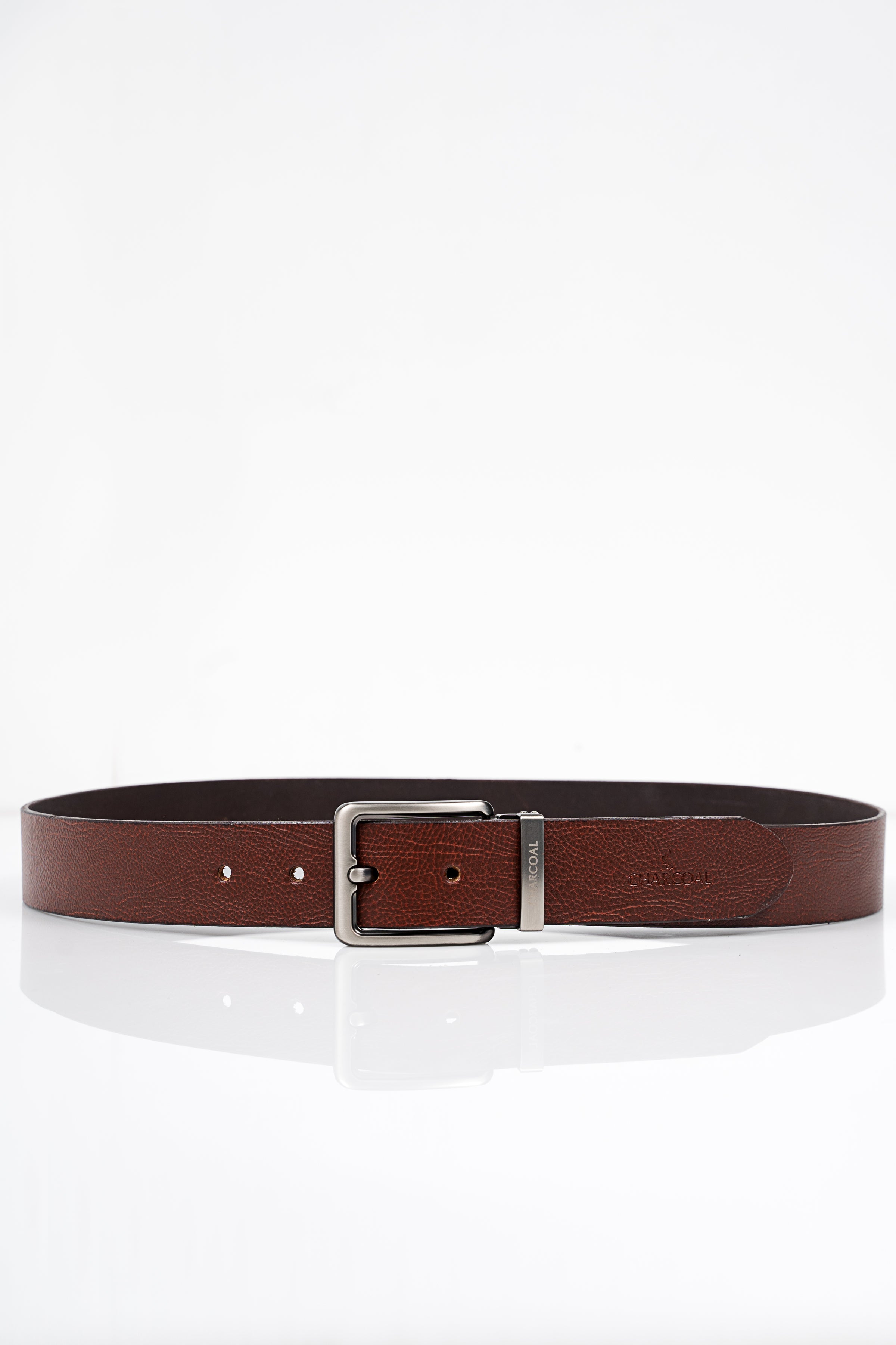 Brown leather belt laid flat with silver square buckle and punched adjustment holes