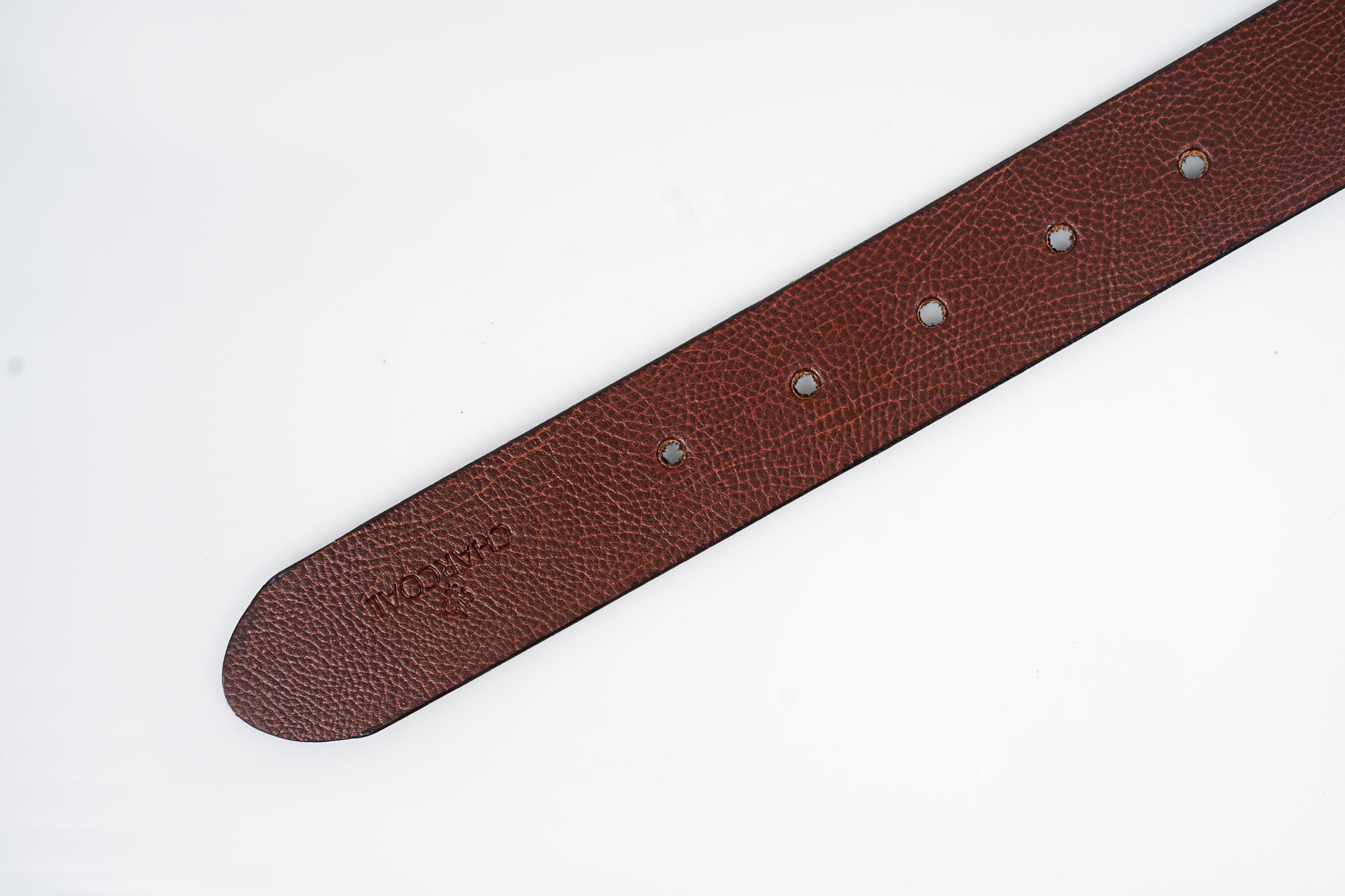 Brown leather belt strap close-up with embossed text and punched adjustment holes