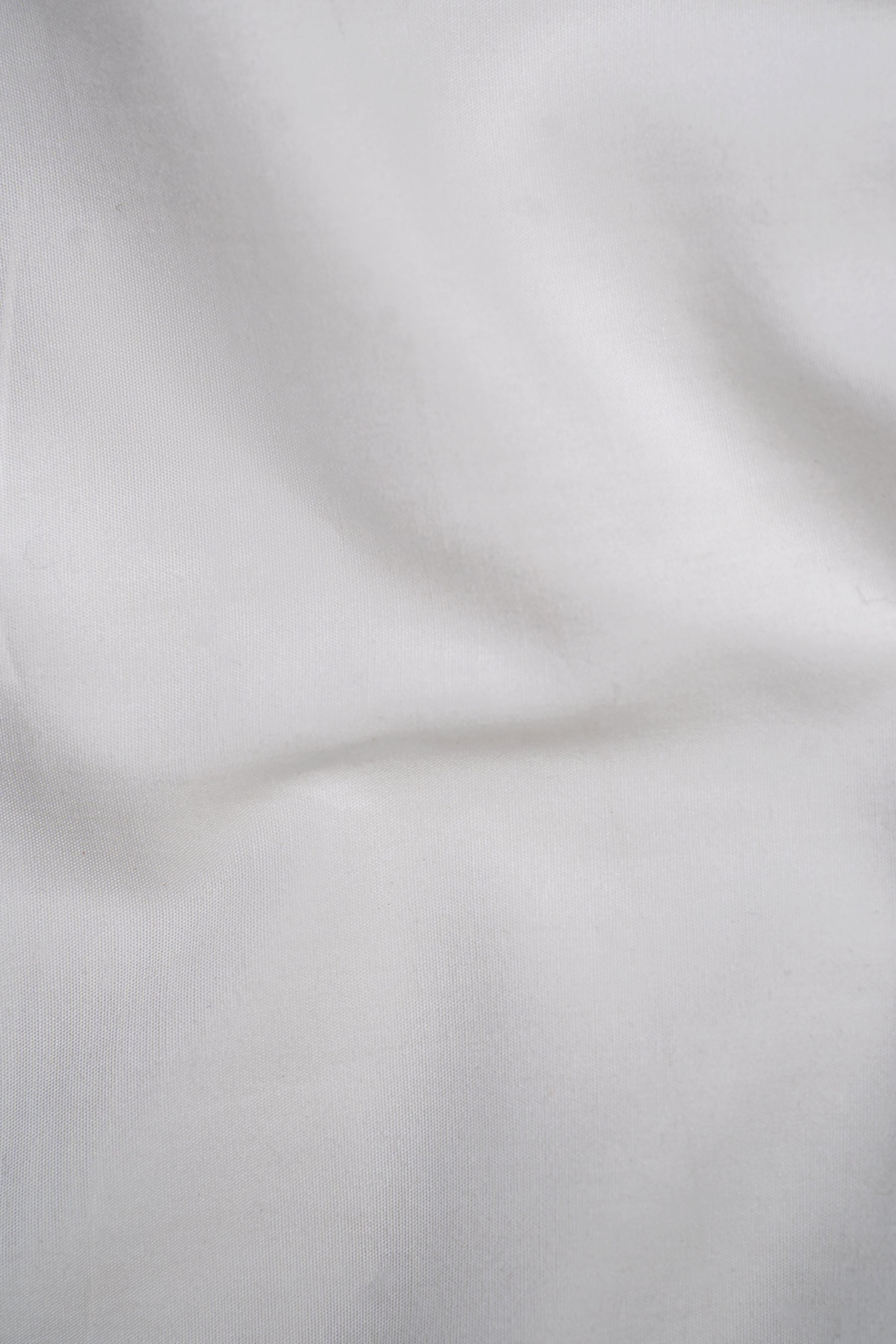 White shirt fabric close-up with subtle texture and creases
