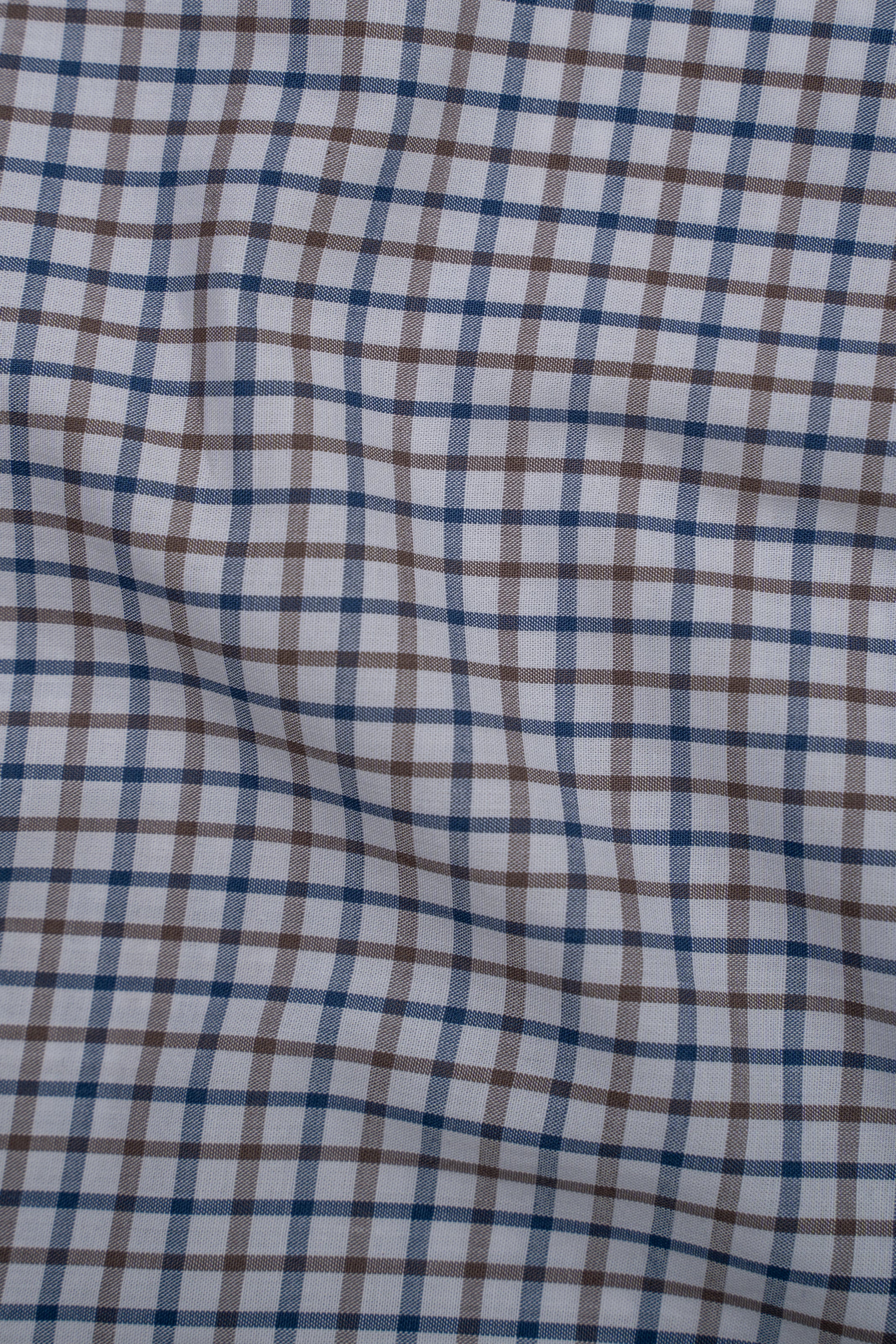 White shirt fabric with blue and brown check pattern, close-up