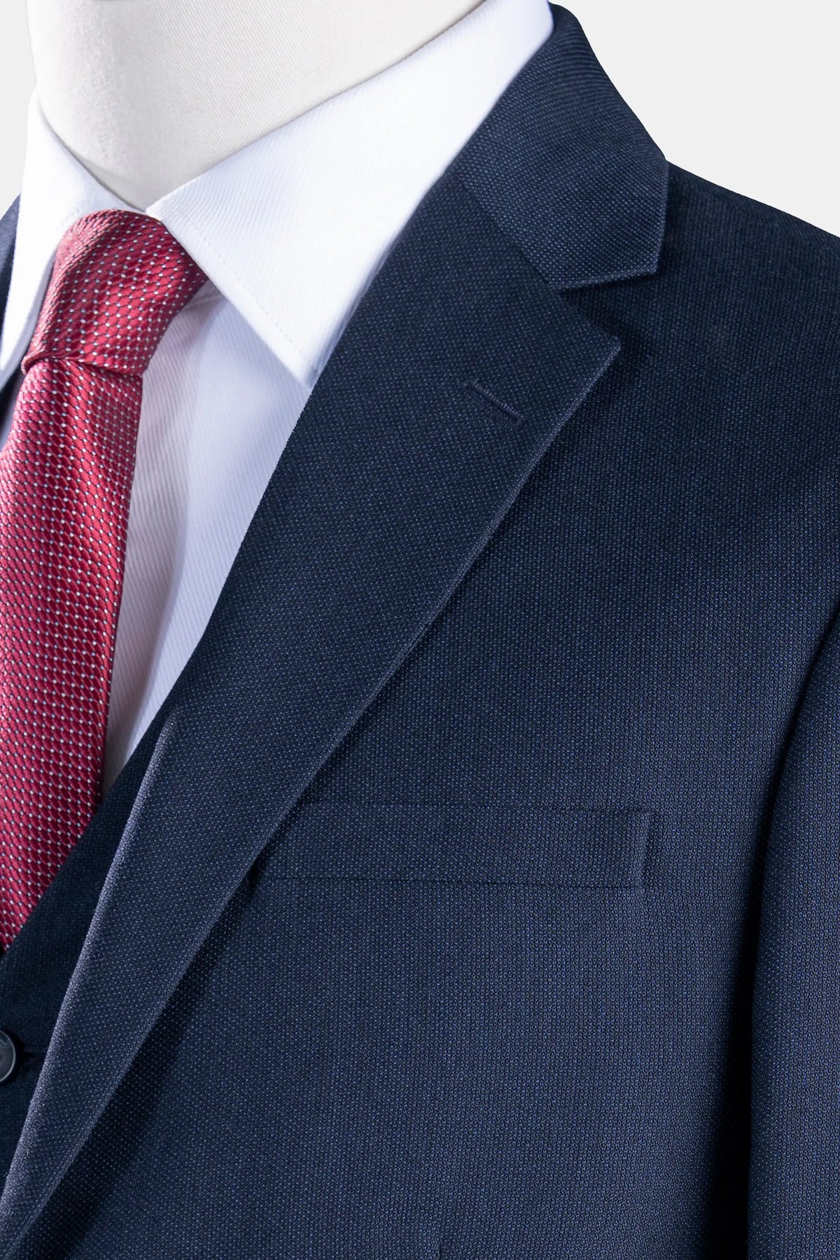 Navy suit blazer with notch lapel and chest pocket, paired with red tie