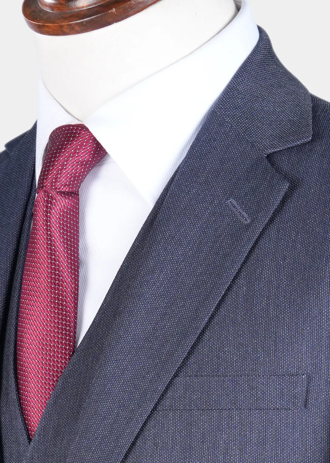 Teal blue blazer with notch lapel and flap pocket detail; red patterned tie.