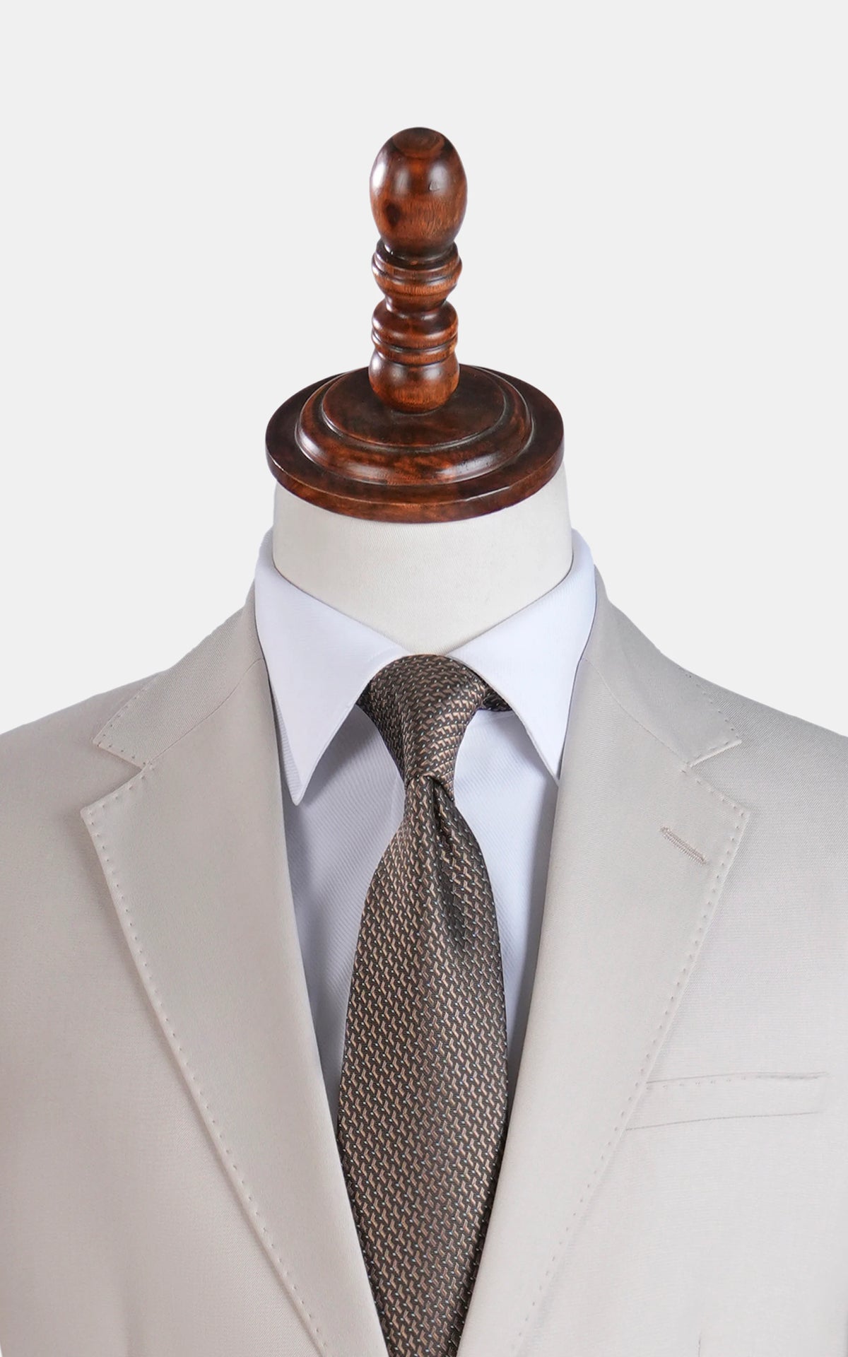 Cream suit jacket with notch lapels, brown patterned tie, white dress shirt