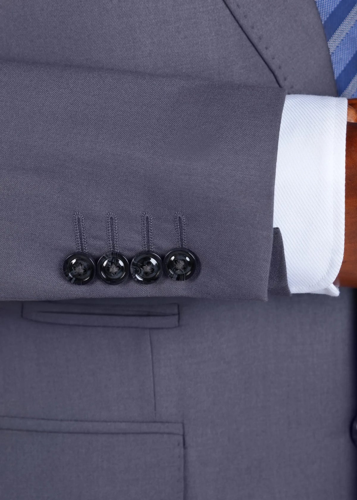 Grey suit jacket sleeve cuff with four black buttons