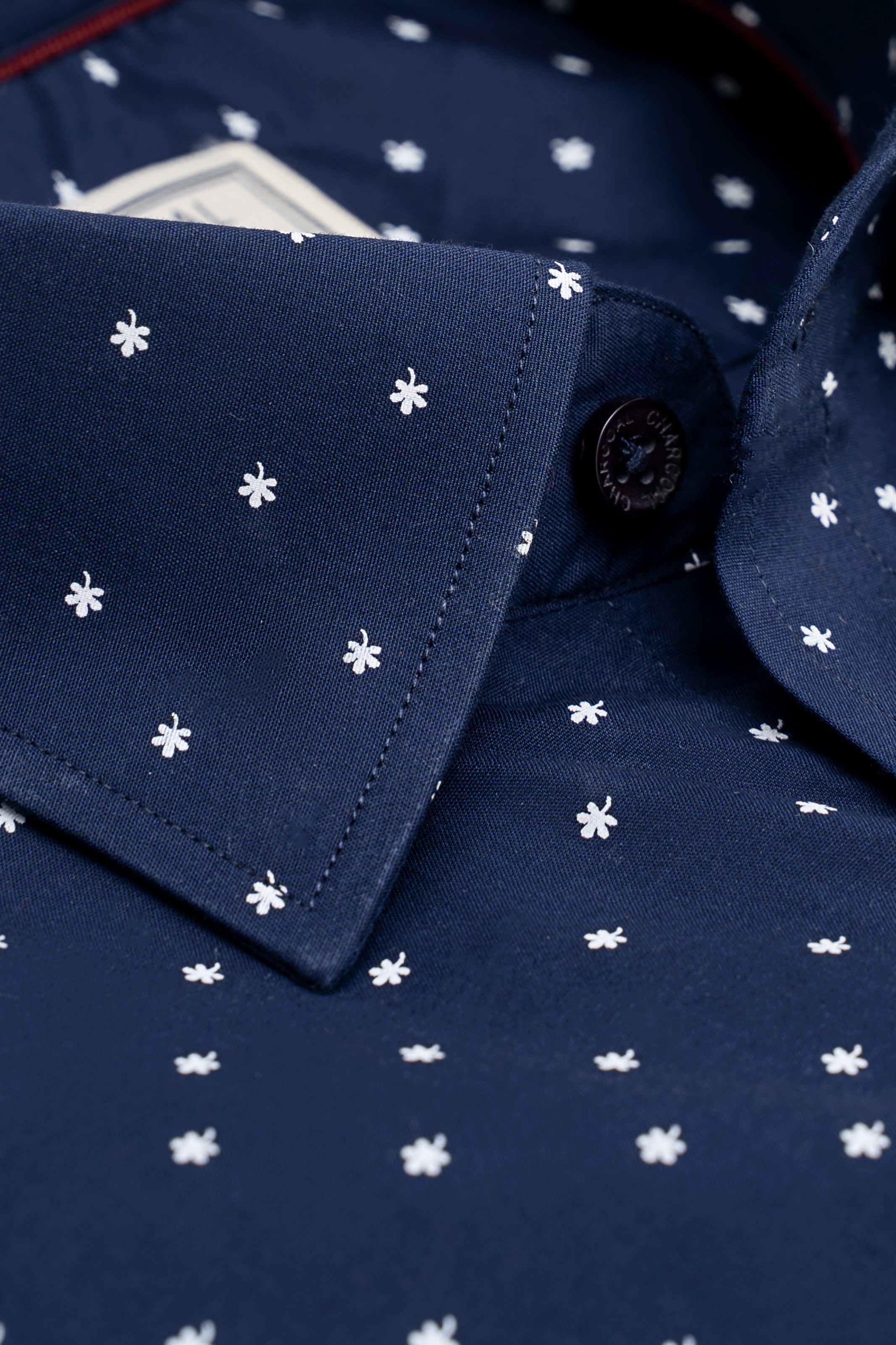 Navy shirt collar and button placket with small white clover/star print