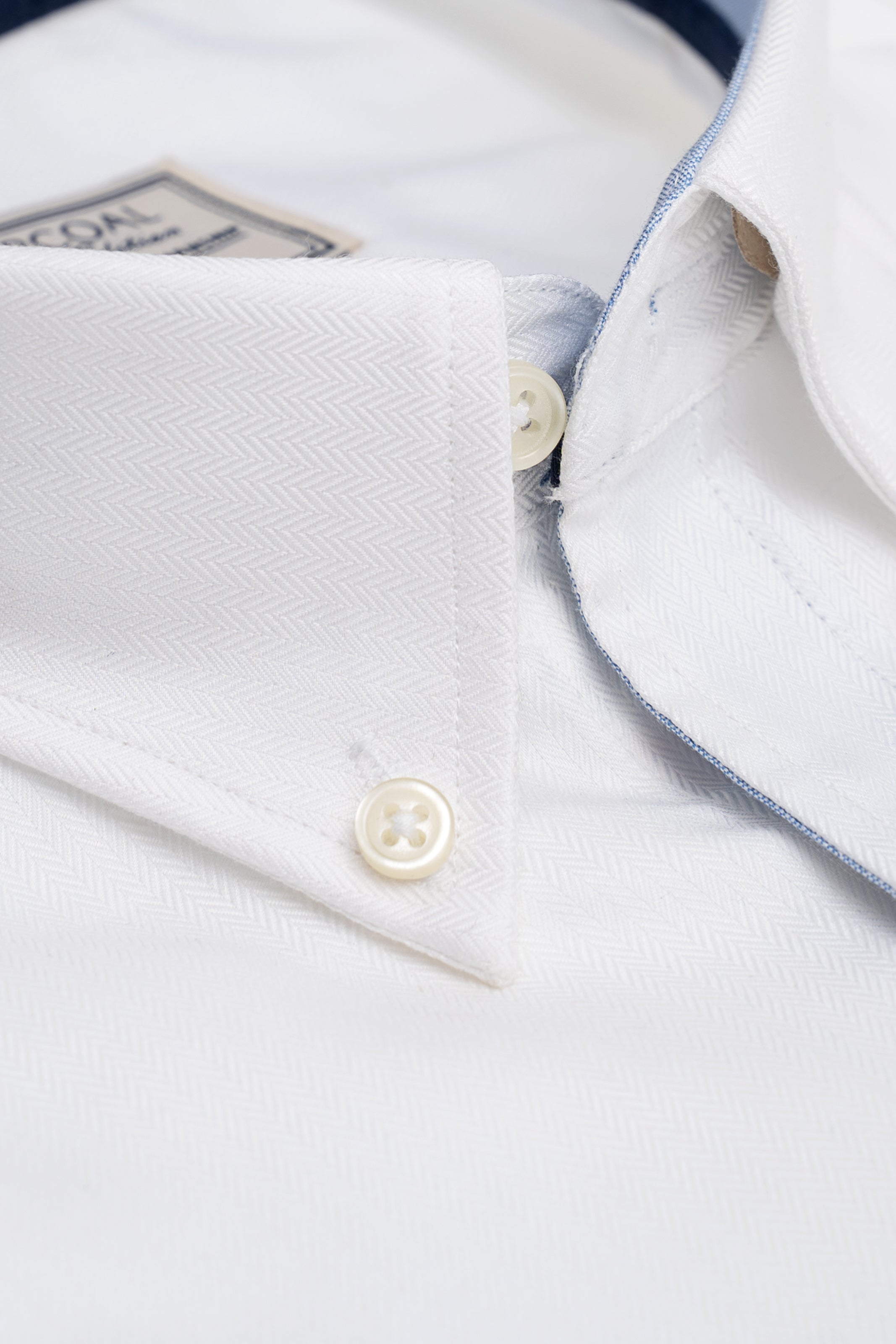 White button-up shirt collar detail with cream buttons and contrast inner placket