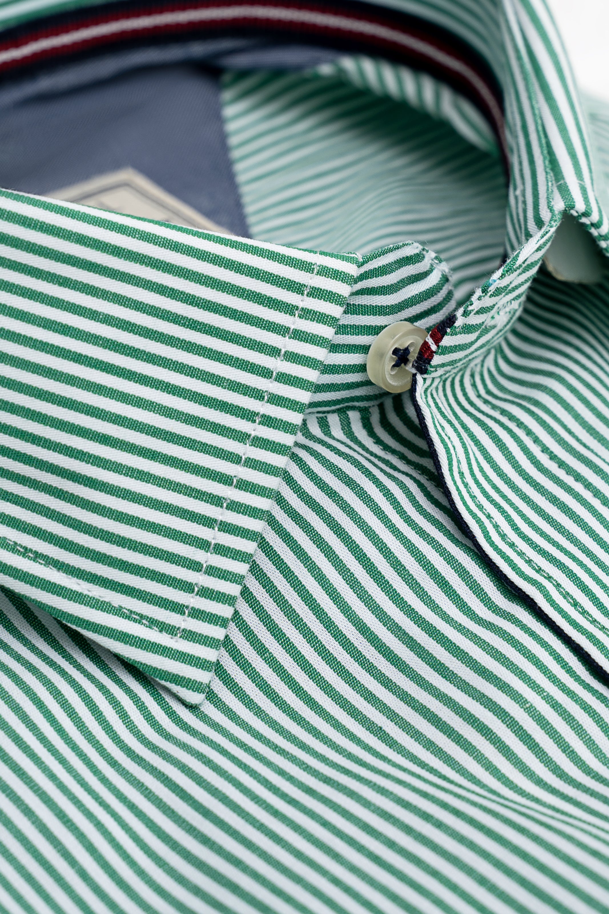 Green-and-white striped shirt collar with white button and stitched placket