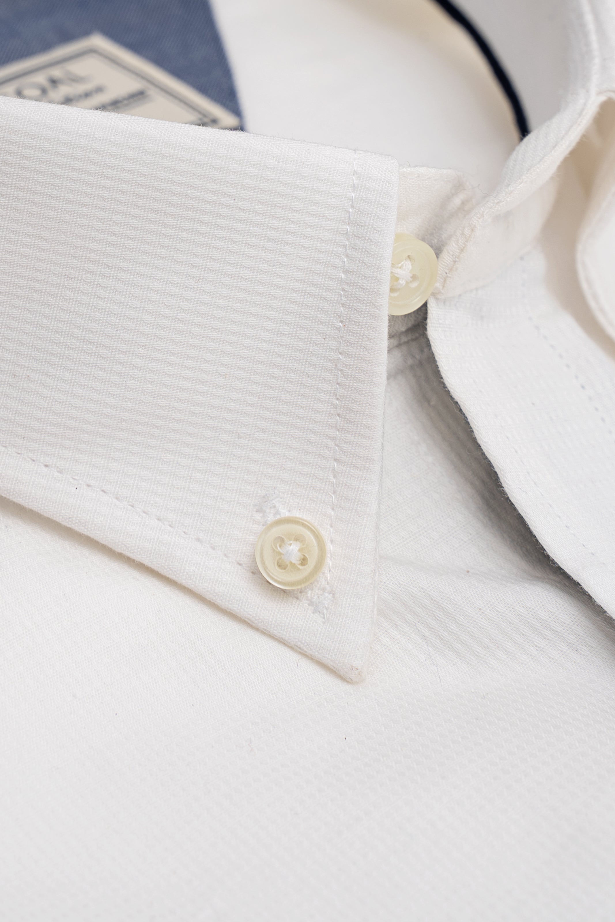 White shirt cuff and button placket close-up with textured fabric