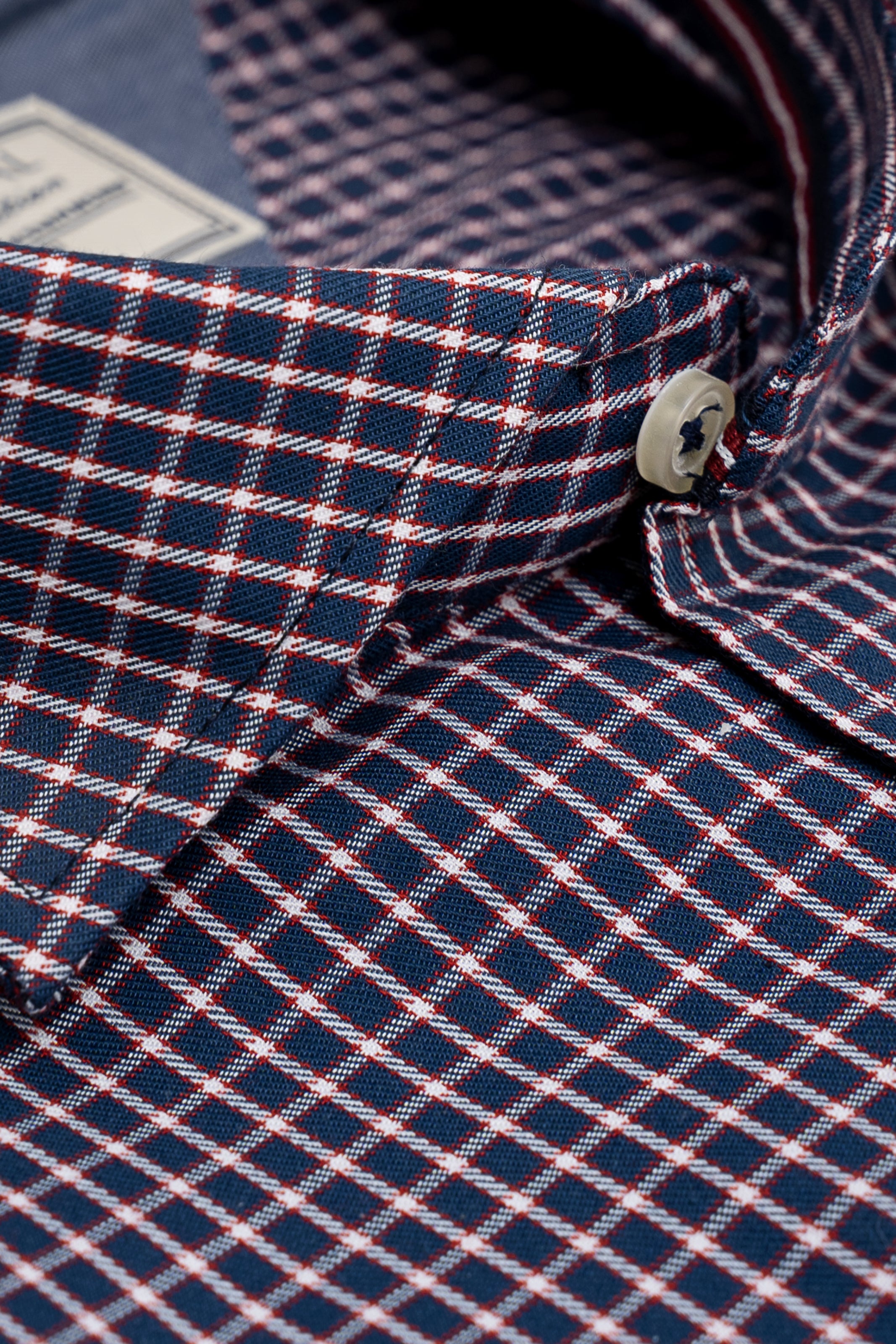 Limited edition check shirt close-up of buttoned collar and neck label, red/black plaid