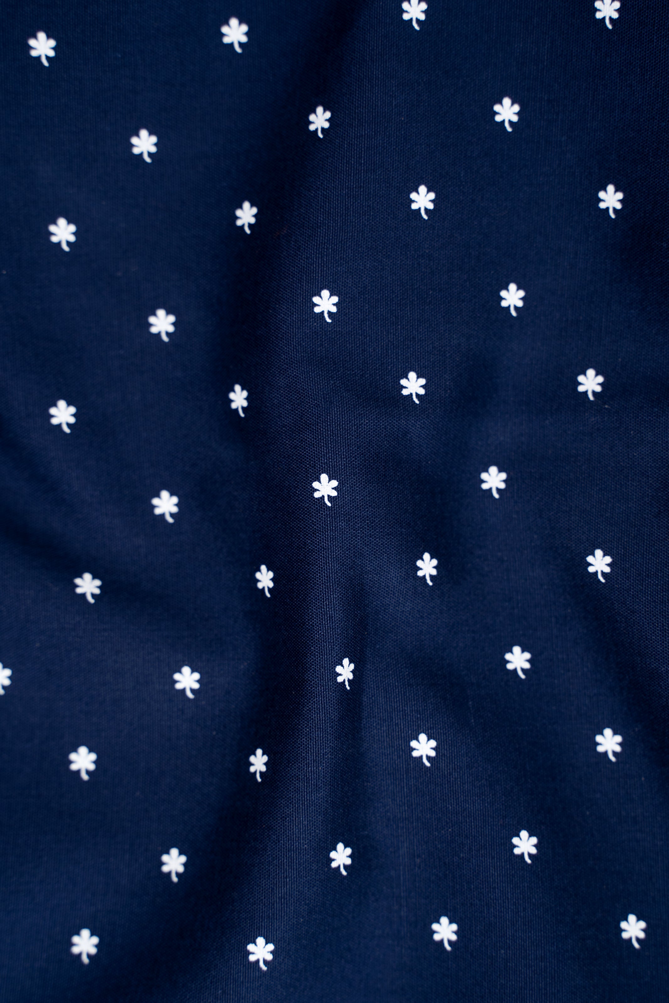 Navy shirt fabric with scattered small white clover/star motifs