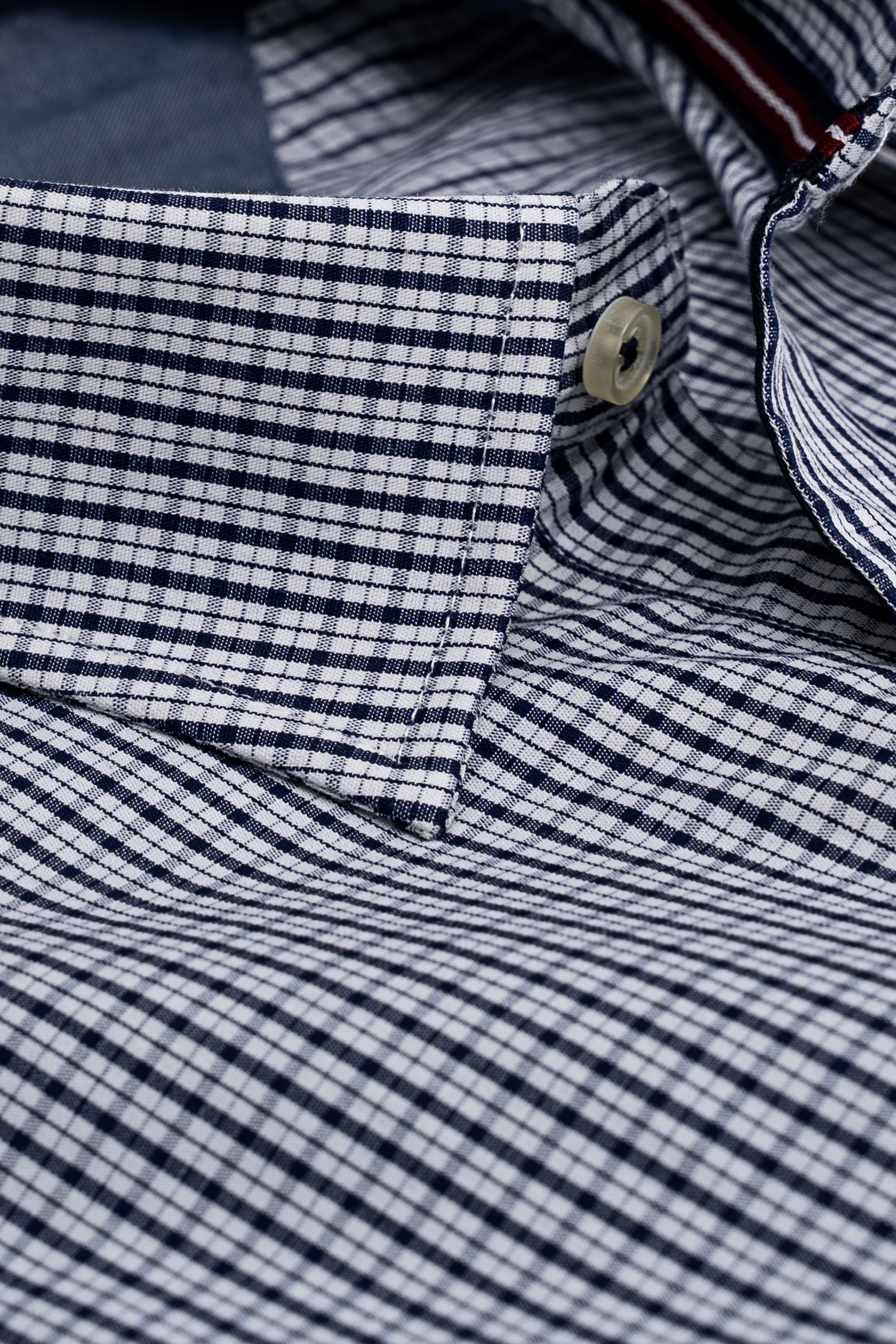 Navy and white checked dress shirt cuff with button and stitched placket