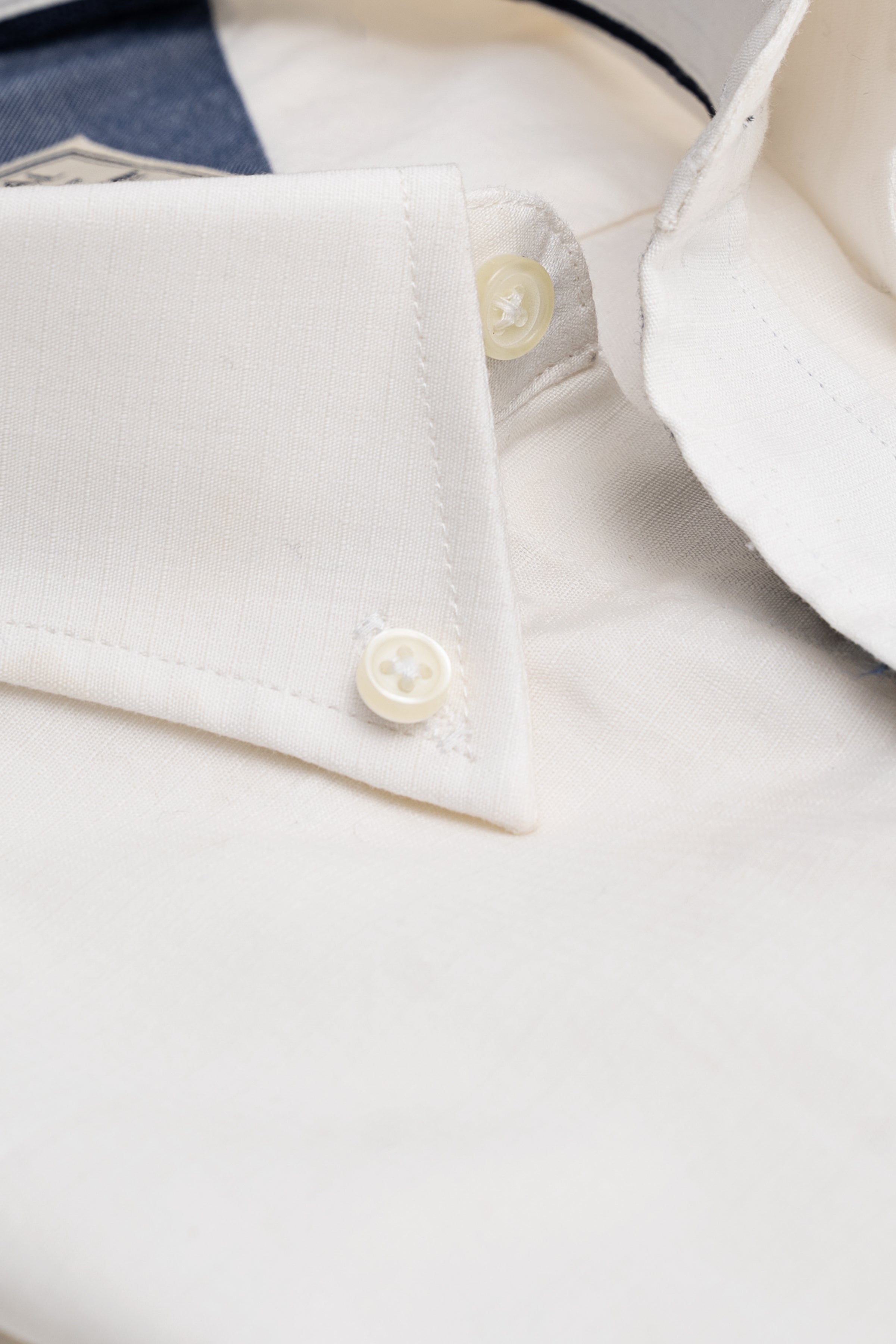 White button-up shirt close-up of collar, seam, and round buttons
