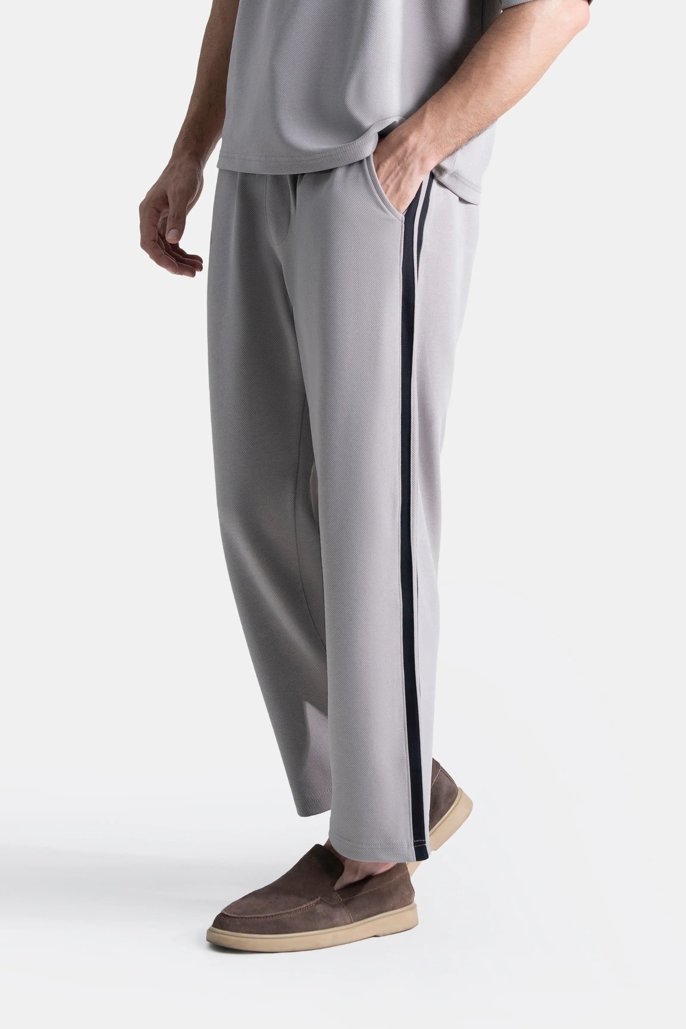 Grey loose-fit trousers with navy side stripe, relaxed straight leg