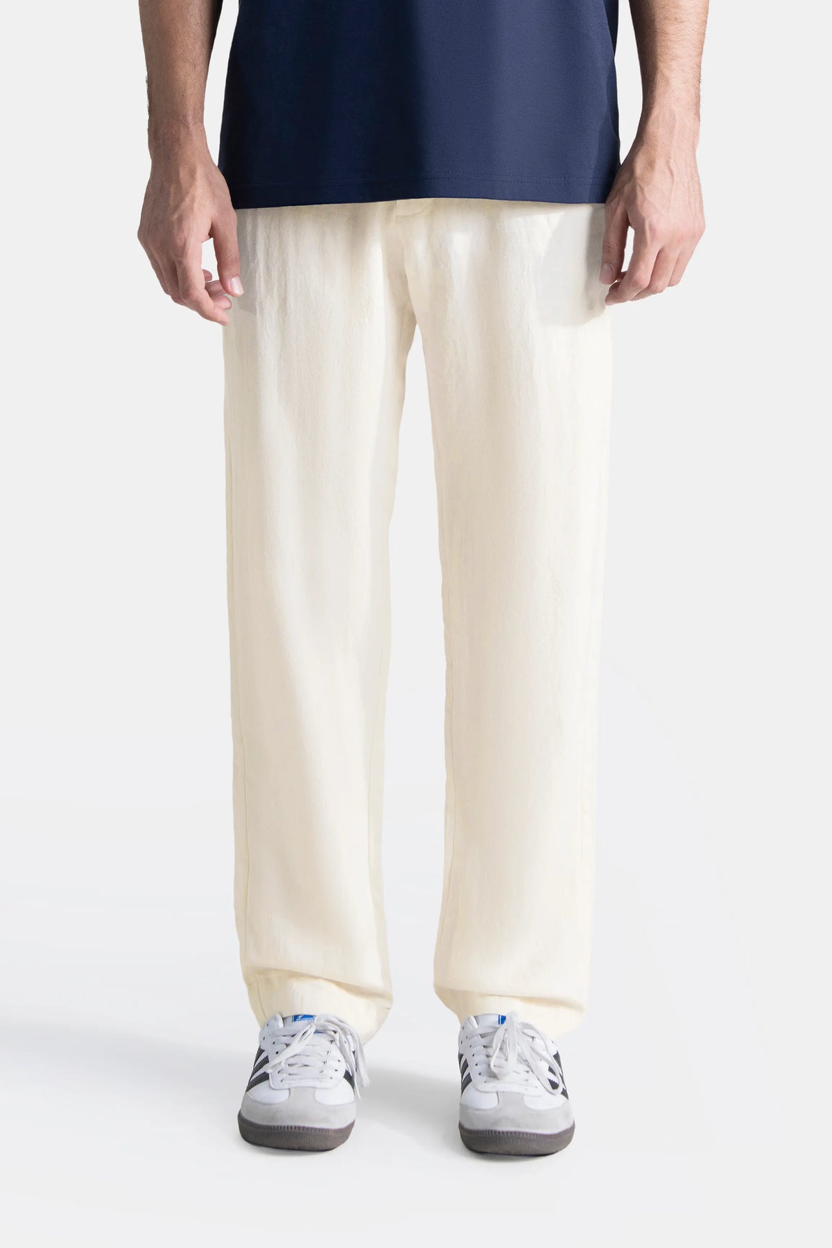 Off-white straight-leg pants on model, front view with sneakers