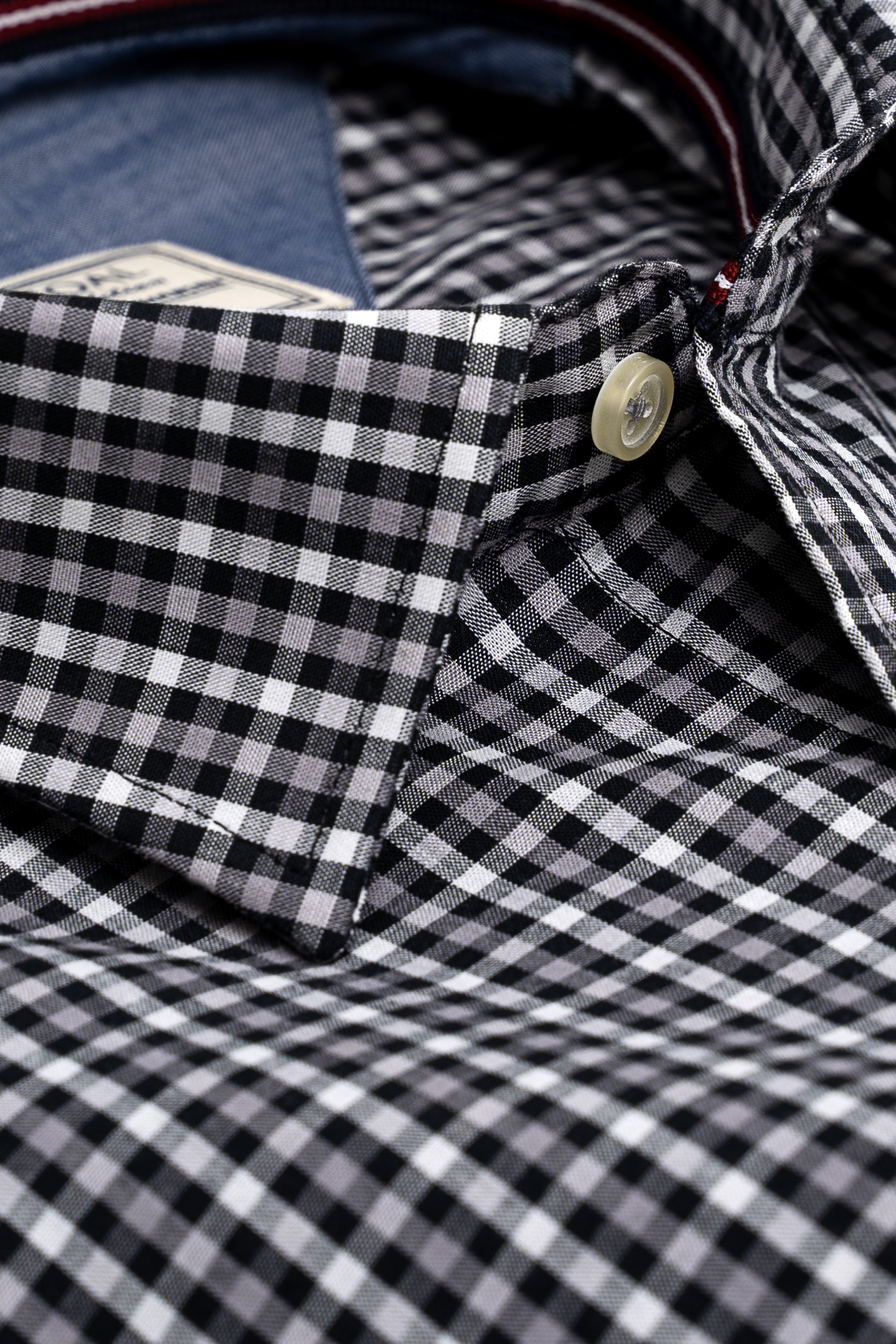 Black and white check shirt cuff with button and stitched placket
