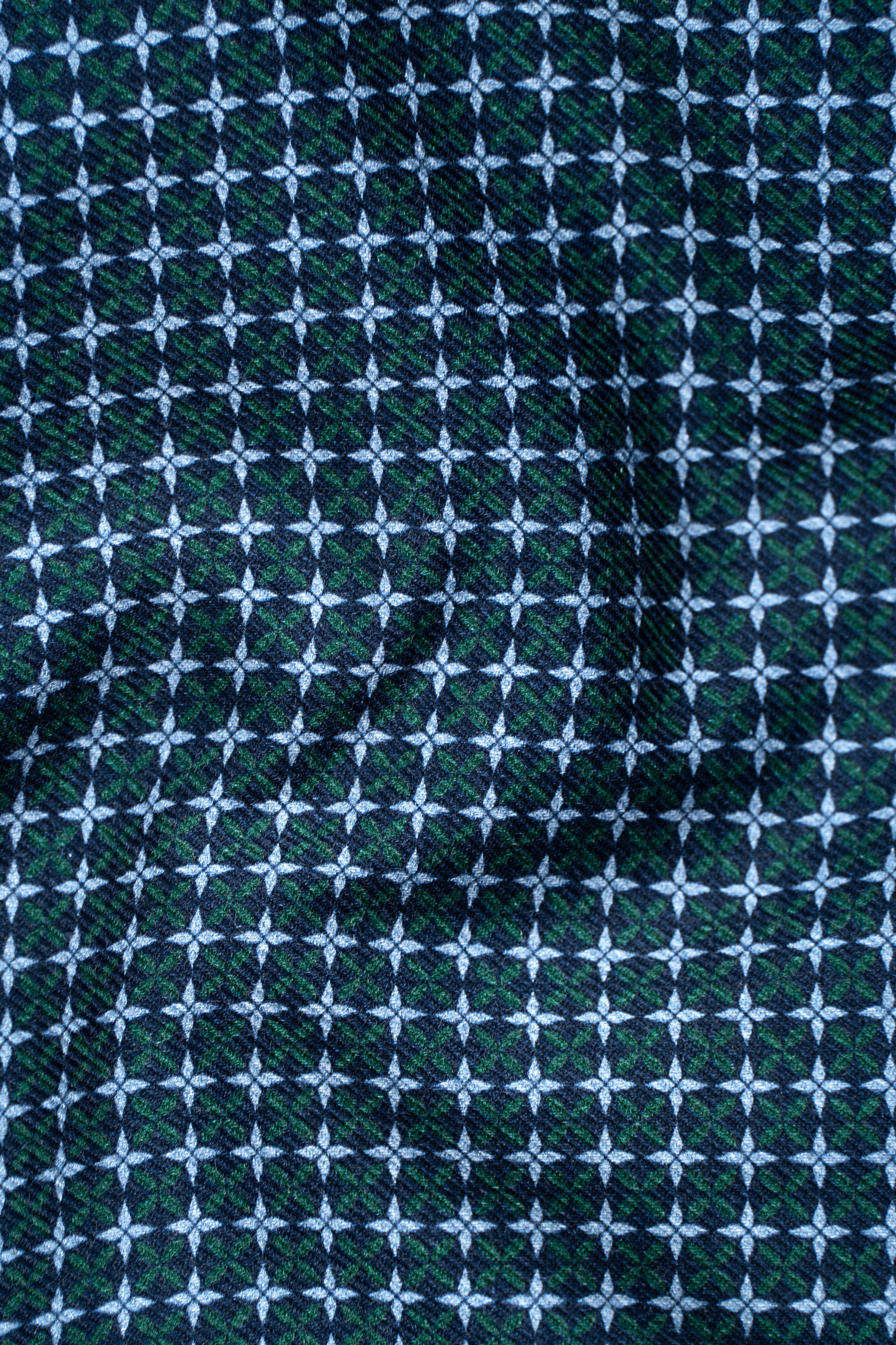 Limited edition shirt fabric with dense geometric grid pattern in green, white, and navy