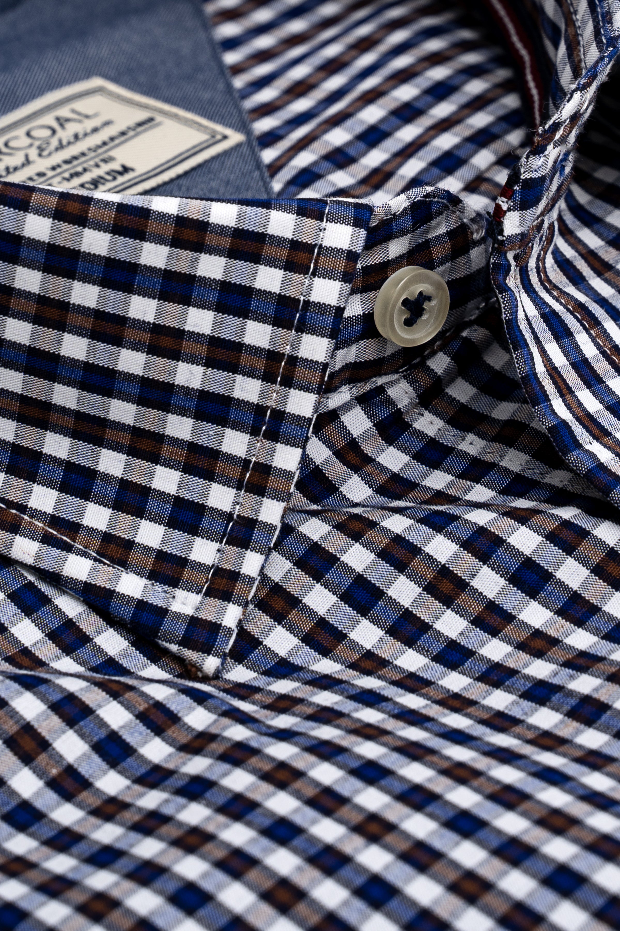 Blue, white and brown check dress shirt close-up of button and folded collar