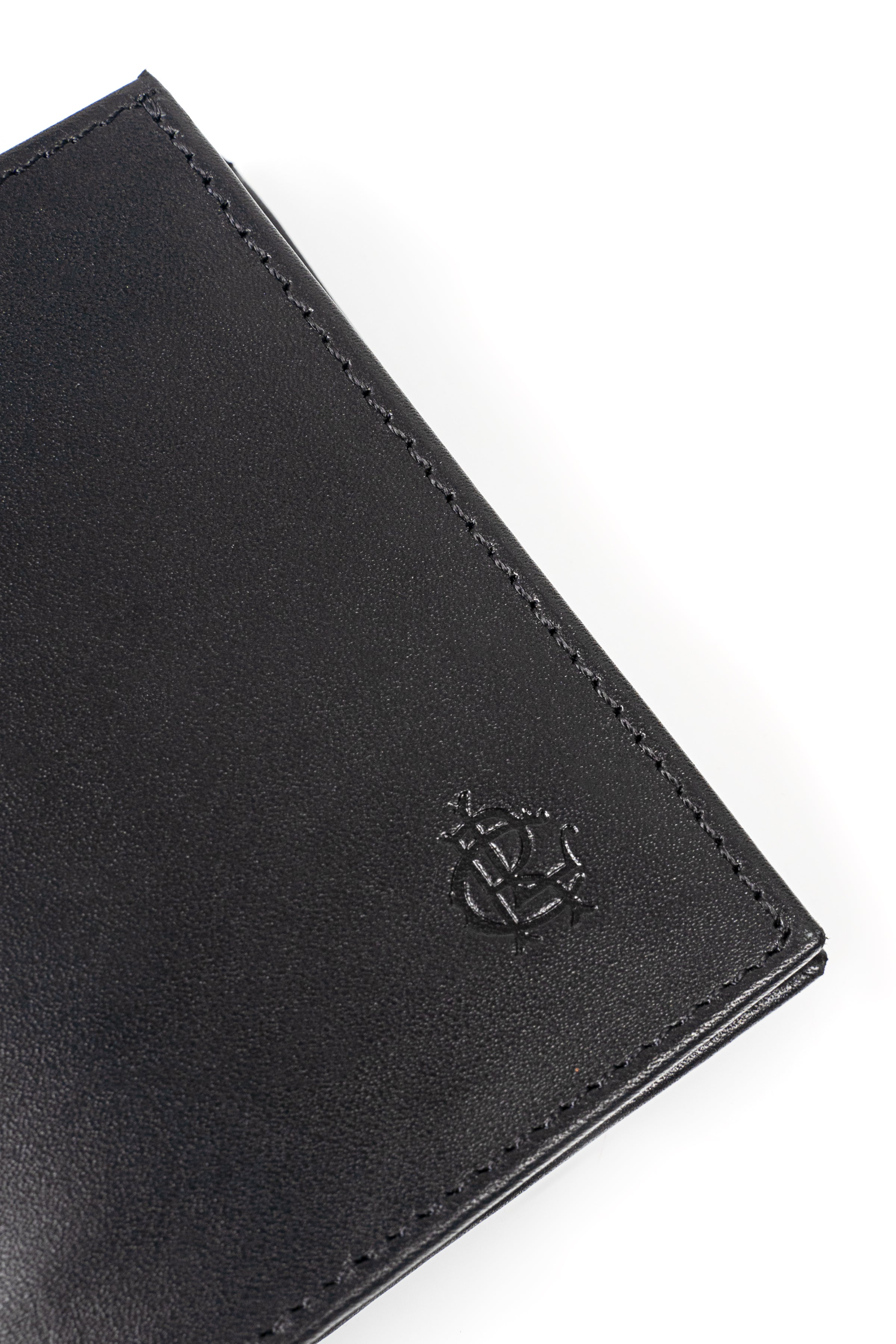 Black wallet close-up with embossed emblem and stitched edge