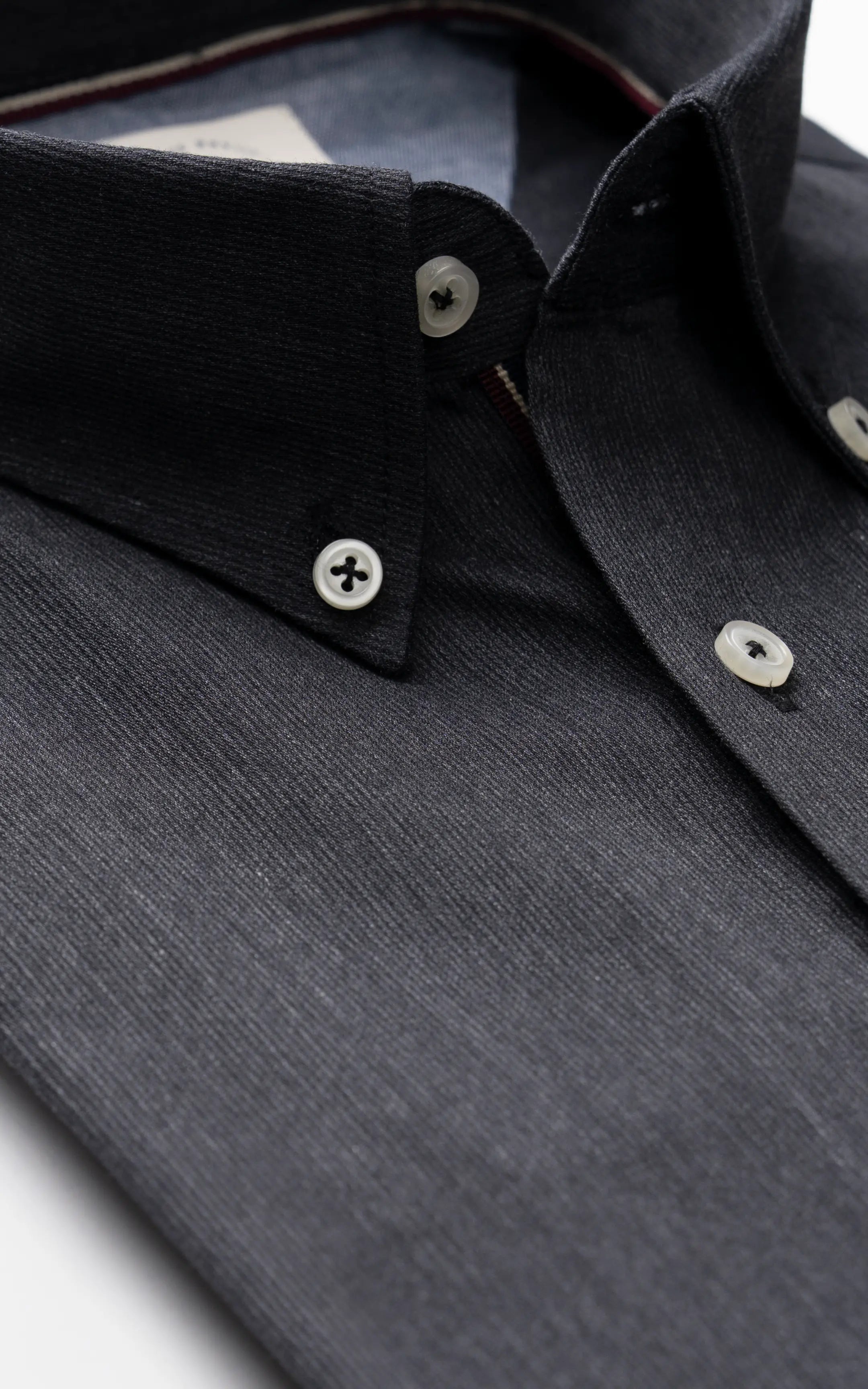 Charcoal grey button-down collar close-up with white buttons