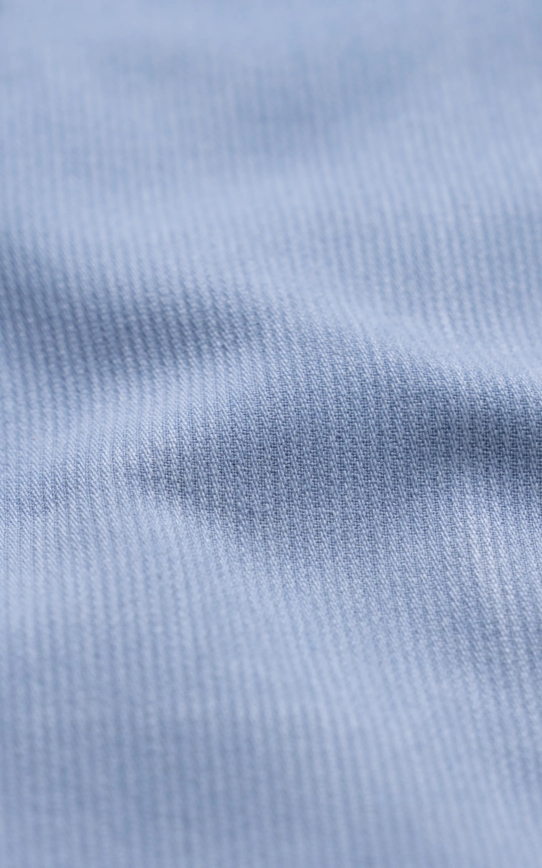 Sky blue shirt fabric close-up with fine woven texture