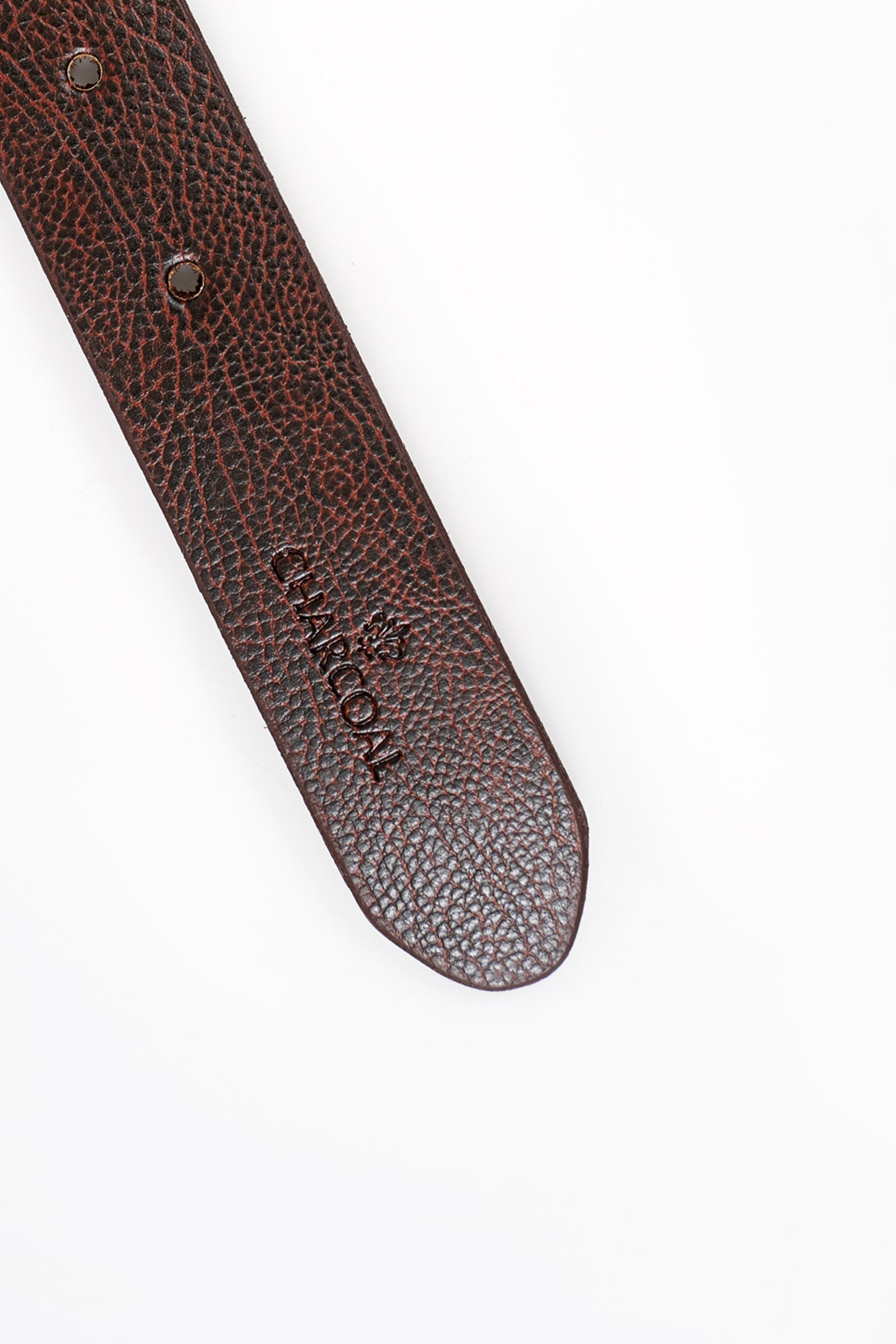 Dark brown textured leather belt end with metal eyelet and small logo patch