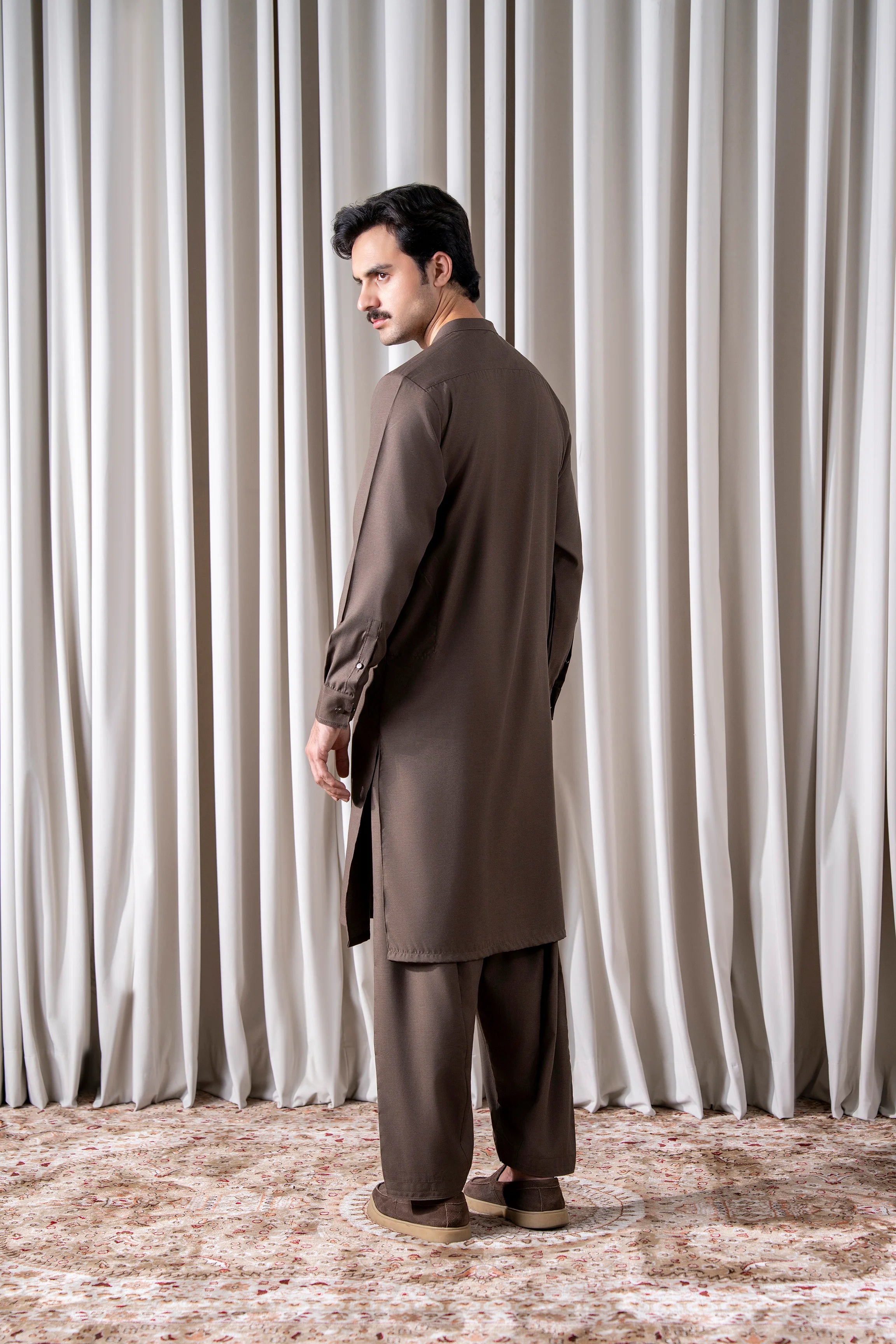 Dark brown textured kameez shalwar set, profile view with long kurta and tapered shalwar