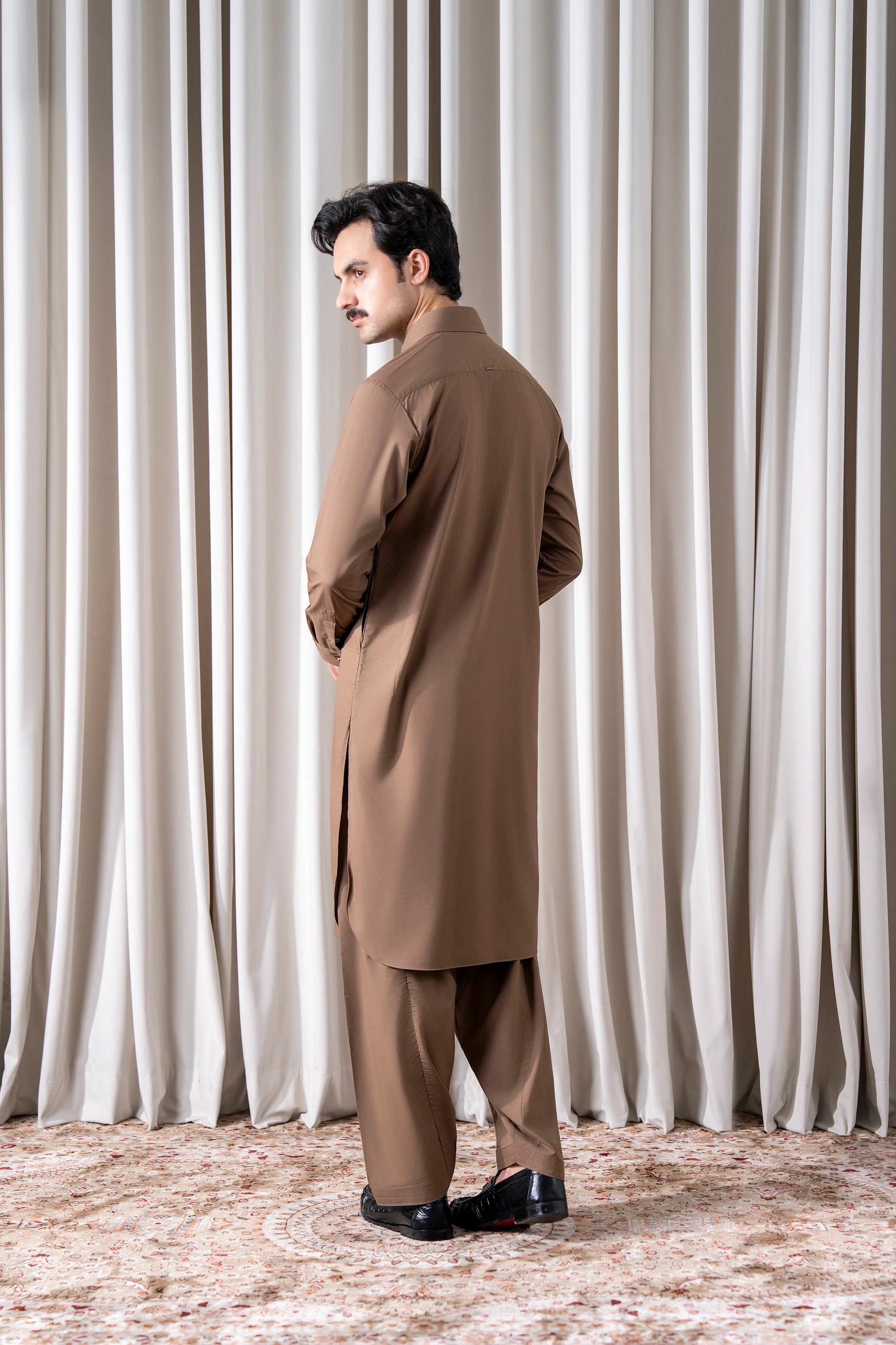Dark khaki kameez shalwar set shown from side, long tunic and matching trousers