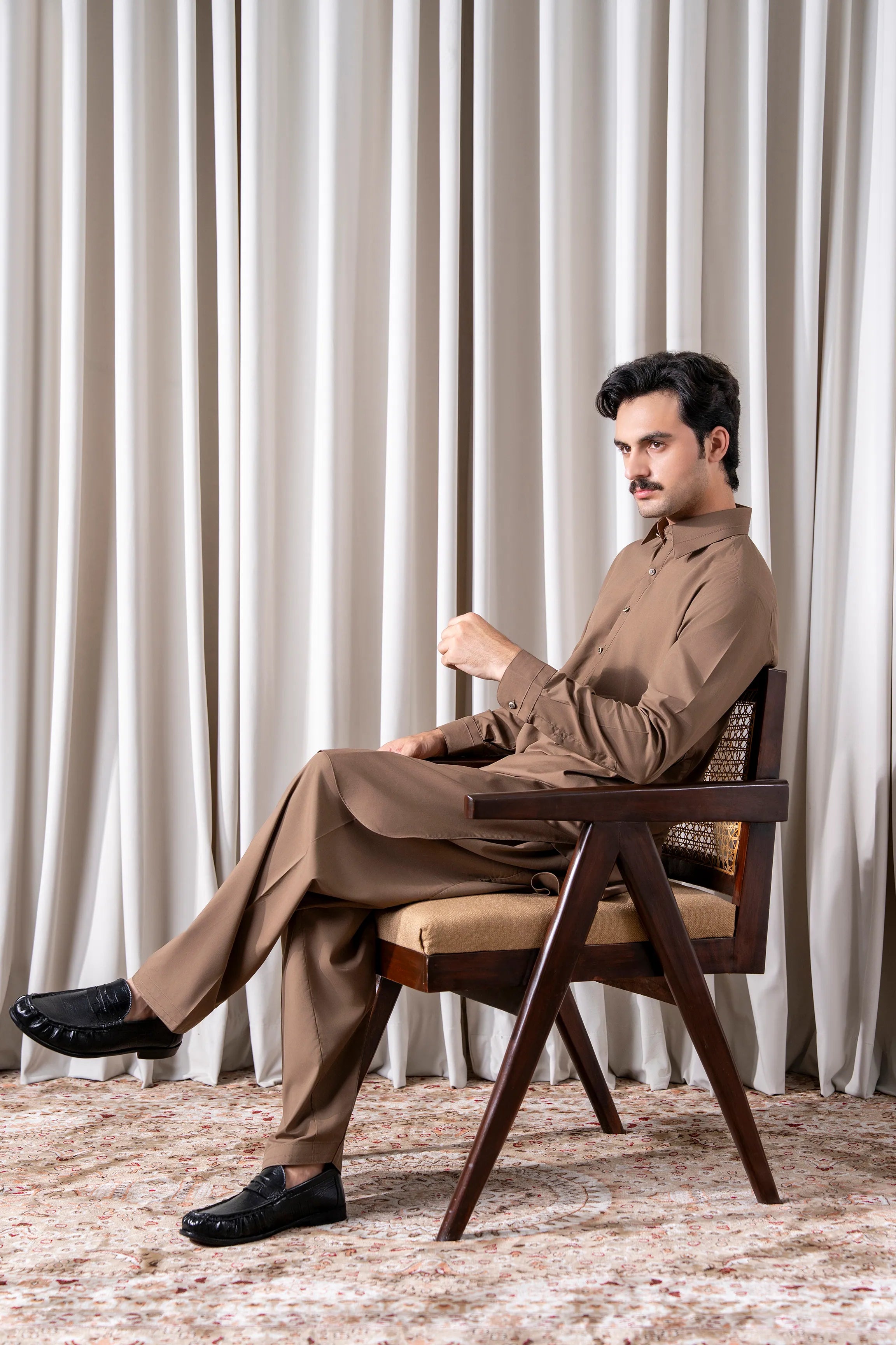 Dark khaki kameez shalwar set seated pose, straight-cut trousers and tunic buttons