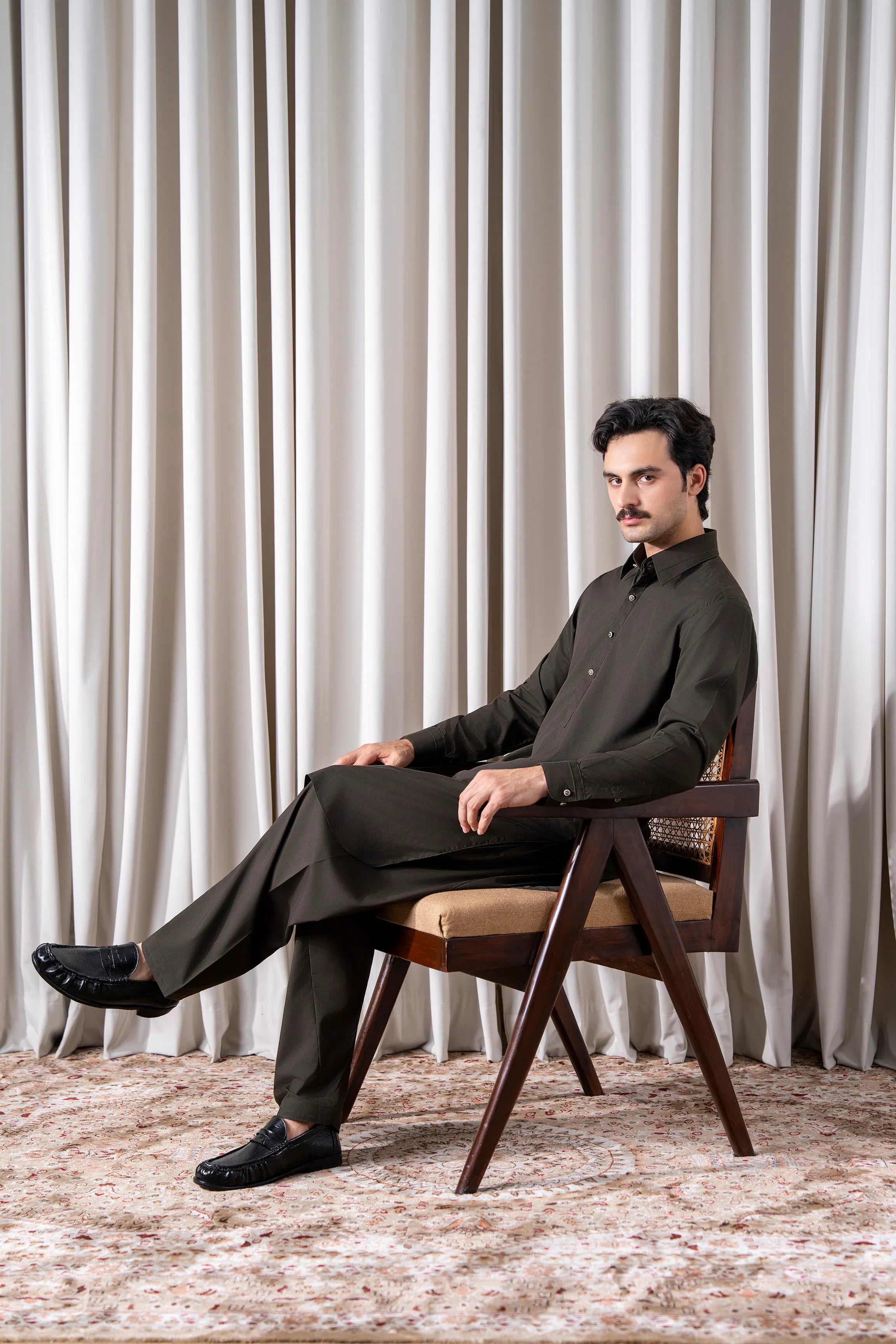 Olive kameez shalwar set with long buttoned kurta and matching slim trousers.
