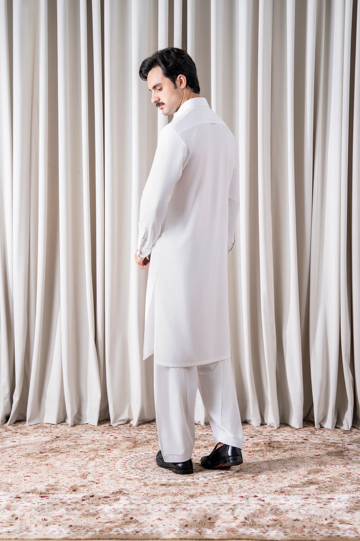 White kameez shalwar set shown from the side, long sleeves and straight tunic