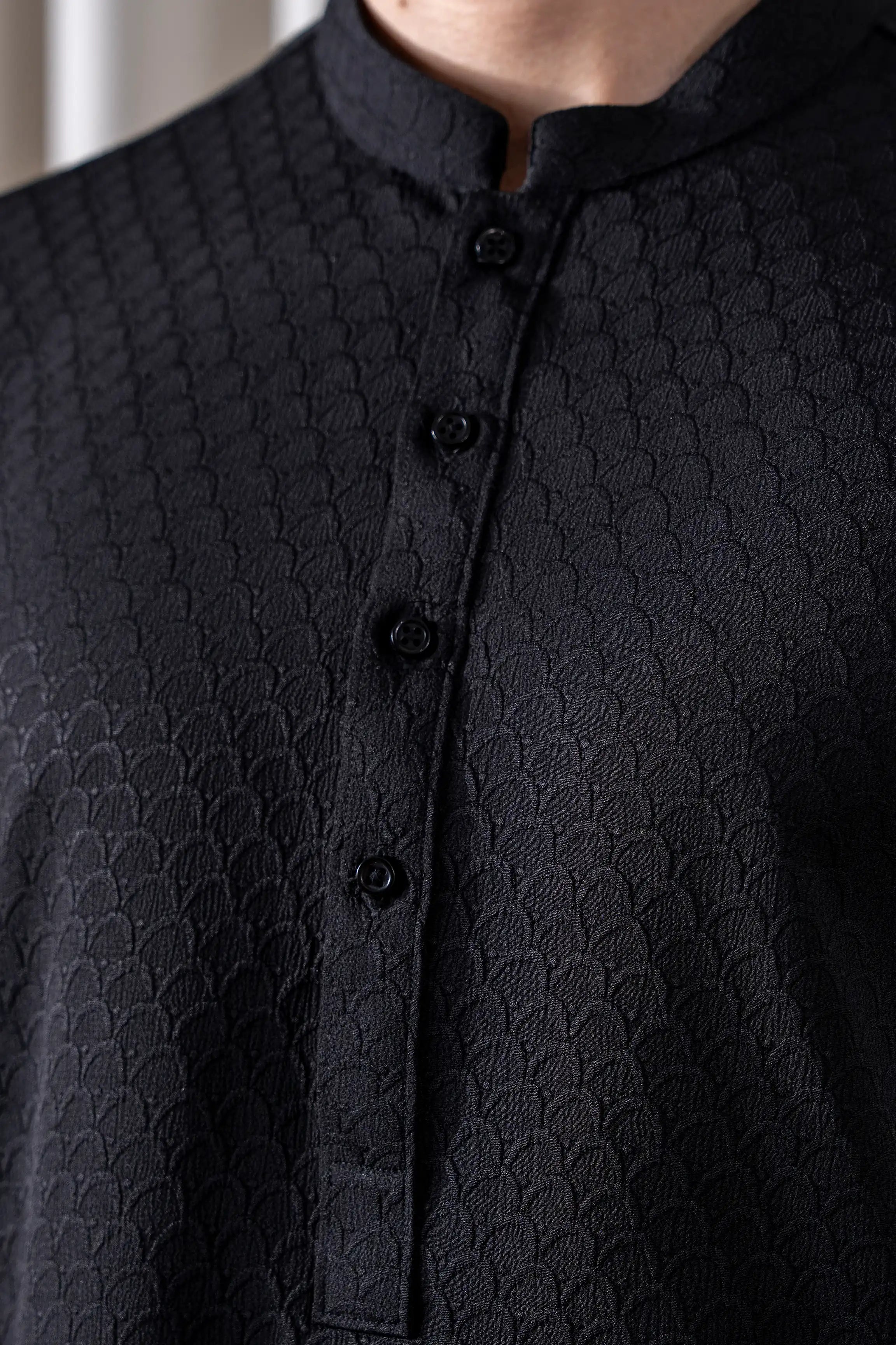 Black textured kurta close-up with mandarin collar and front buttons