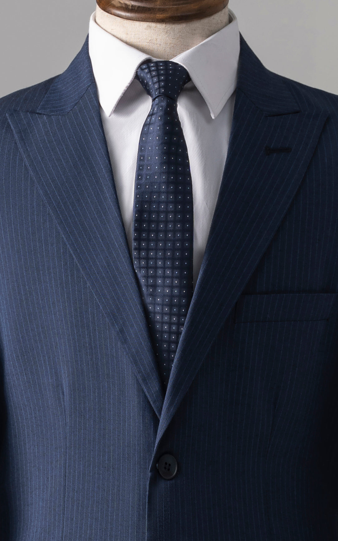 Navy pinstripe suit jacket with white shirt and dark patterned tie