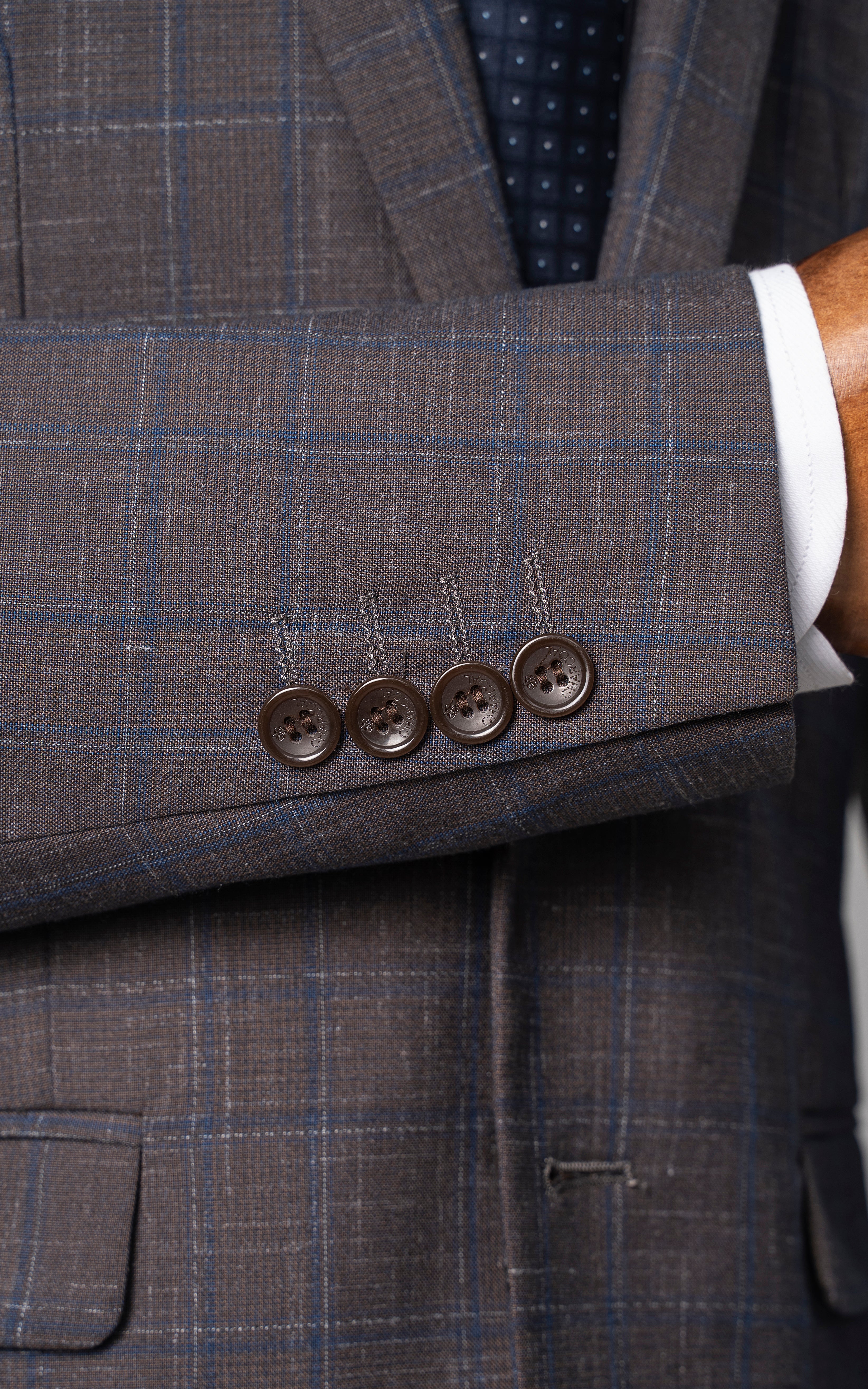 Check suit jacket sleeve with four brown buttons