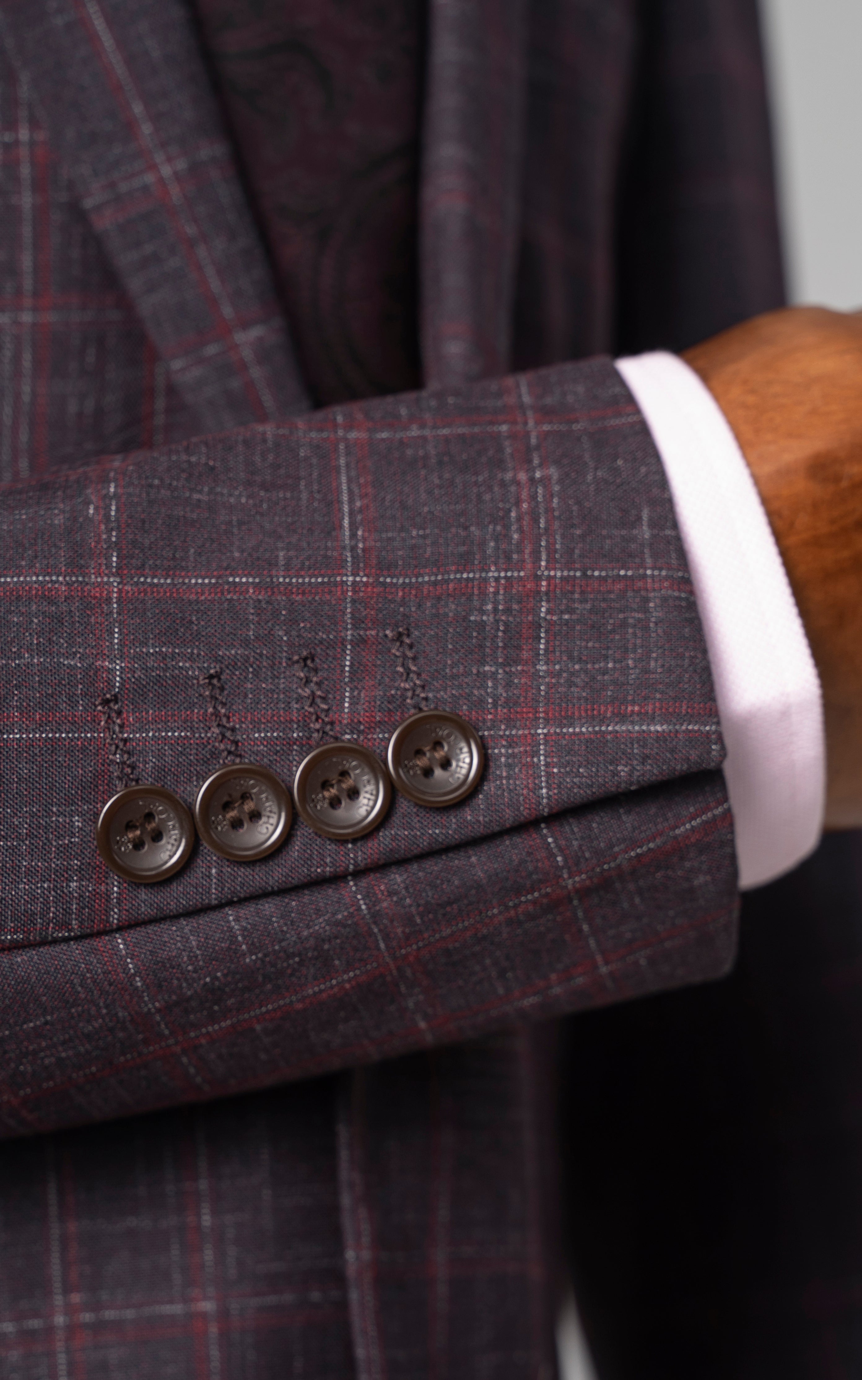 Maroon check suit jacket cuff with four buttons and tailored sleeve
