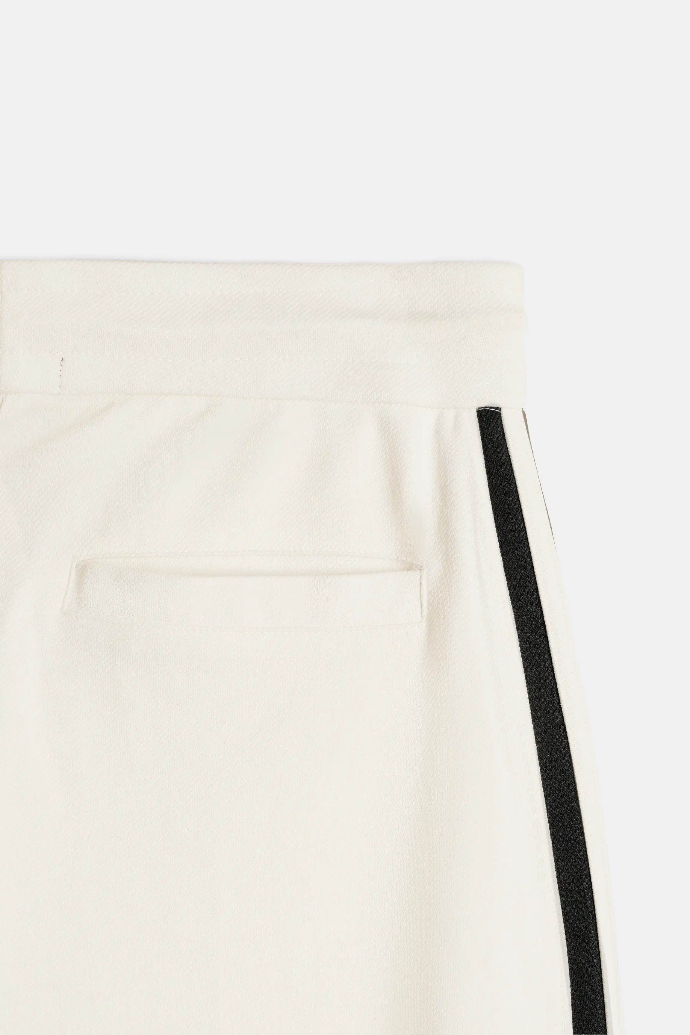 Off-white pocket detail with black side stripe on relaxed trousers