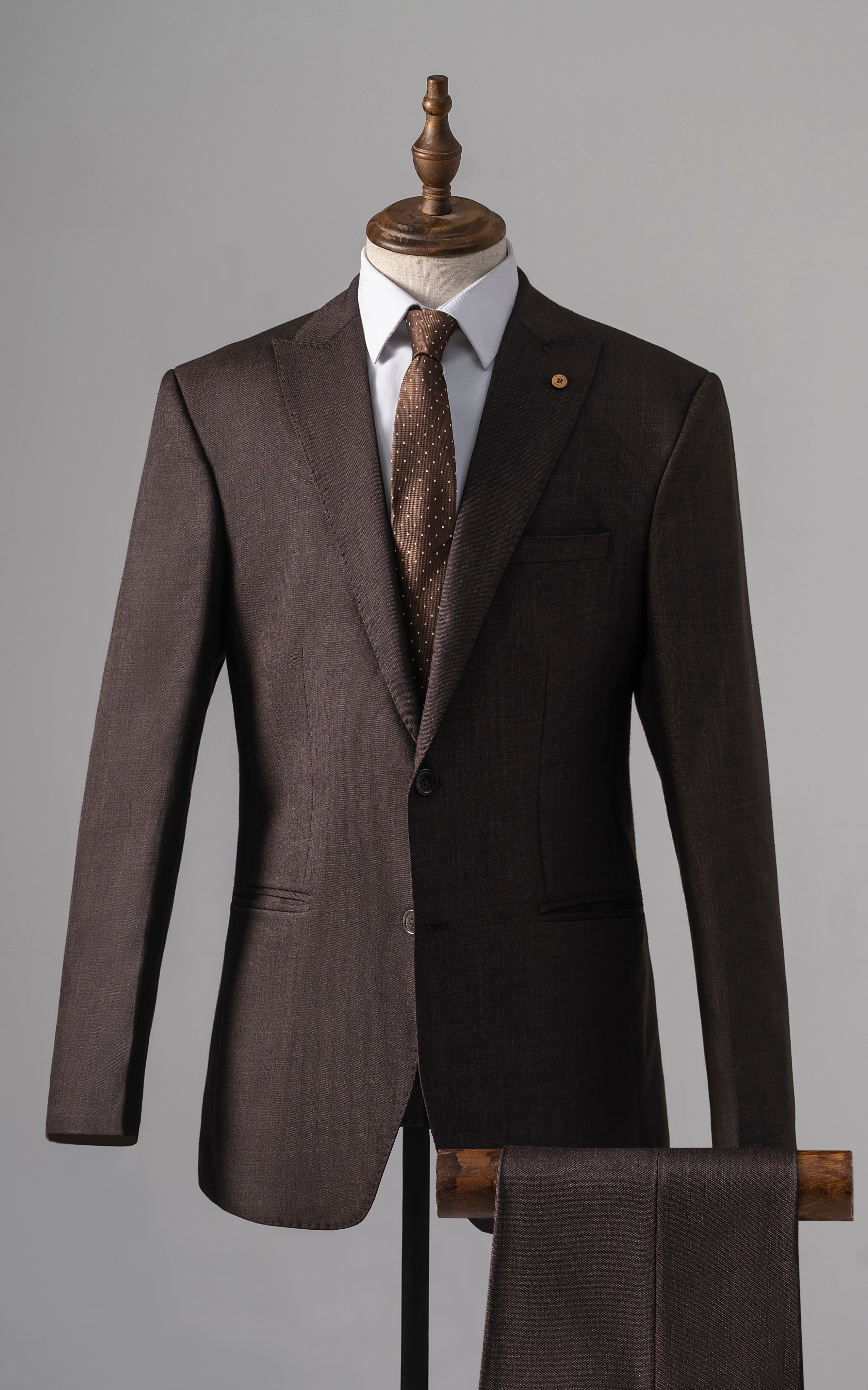Brown two-piece suit with buttoned blazer, dress shirt, and patterned tie