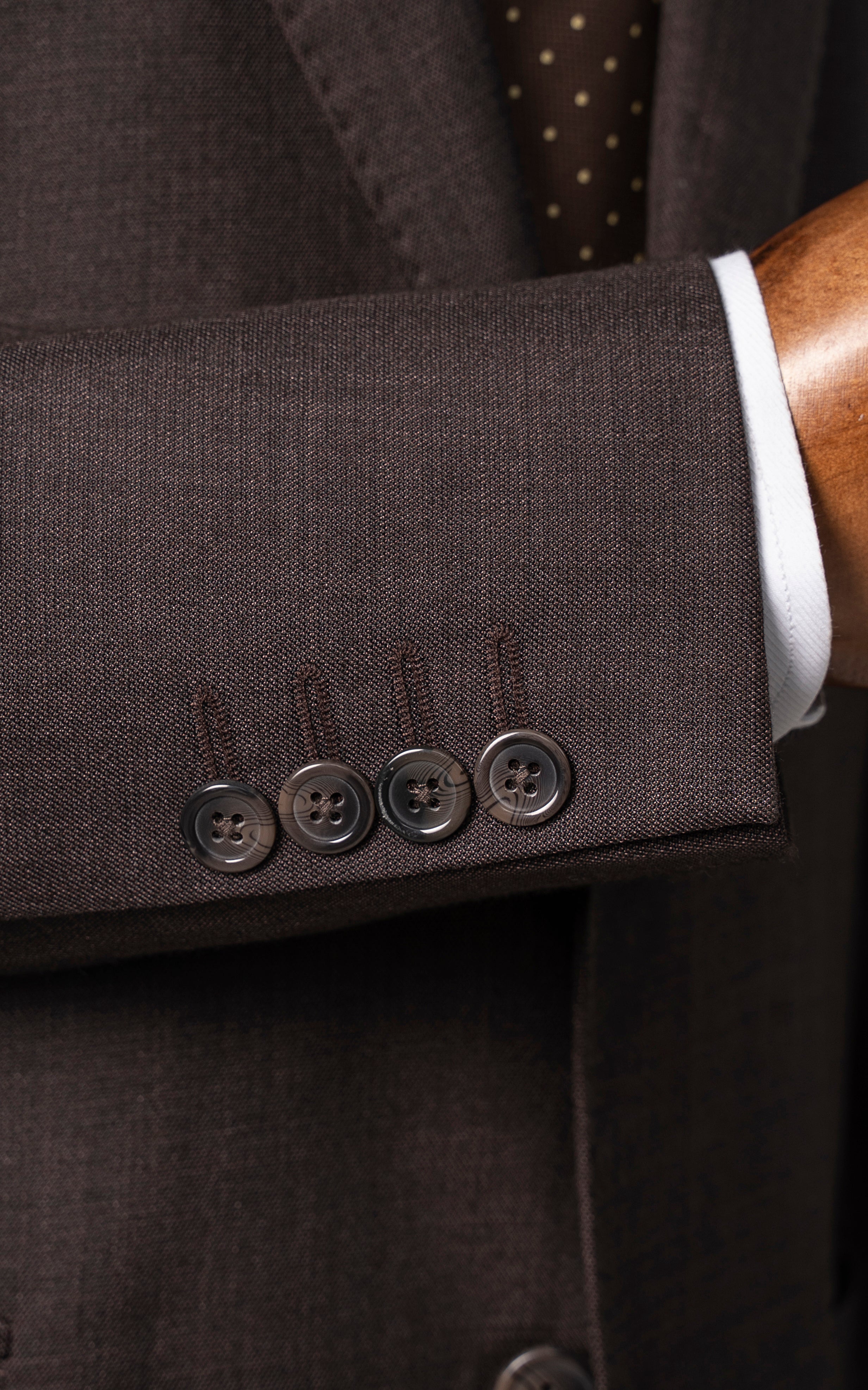 Brown suit jacket cuff with four buttons and front flap pocket