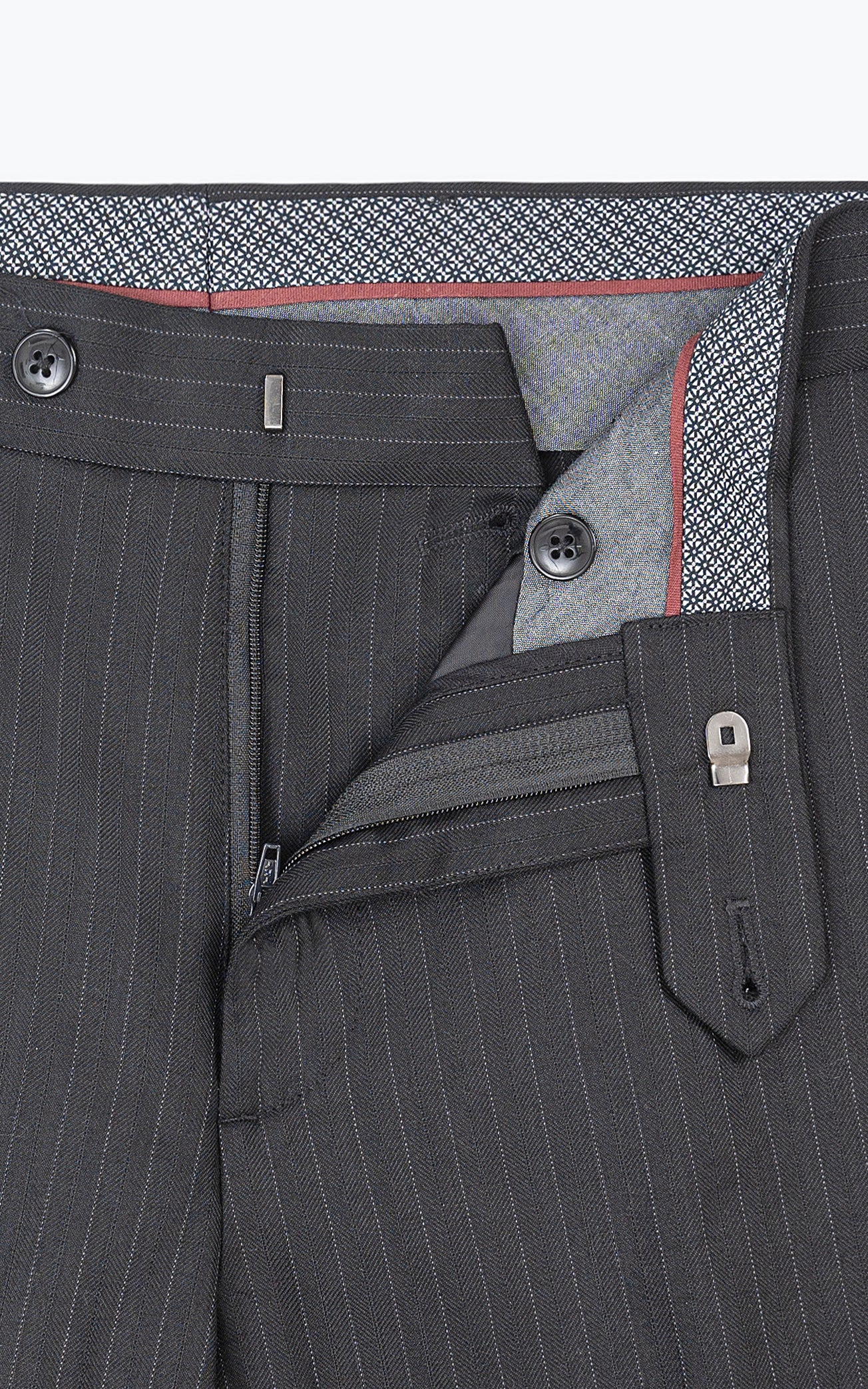Slim-fit dress pants waistband close-up with button closure, belt loops, and front pleats