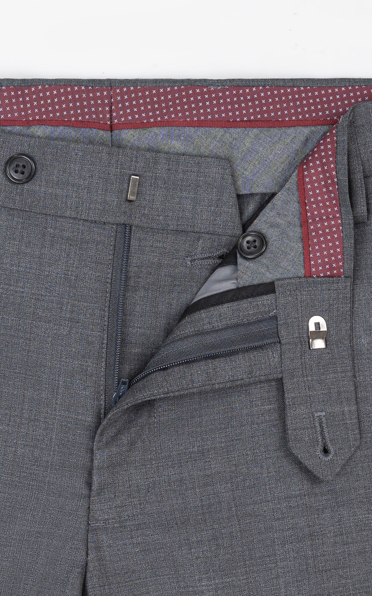 Grey dress pants pocket and waistband detail with belt loop and button