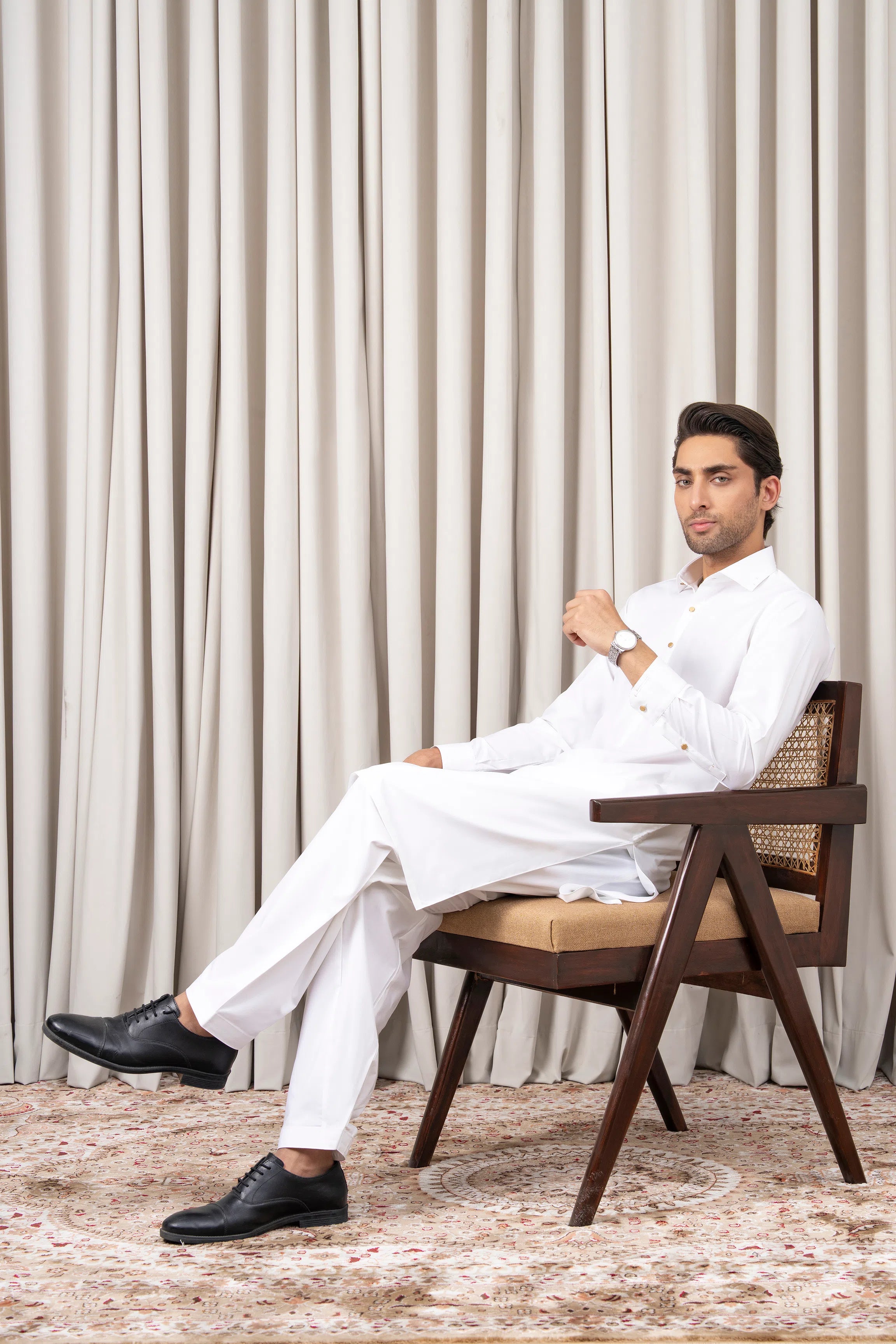 White kameez shalwar set seated pose with long tunic and matching trousers