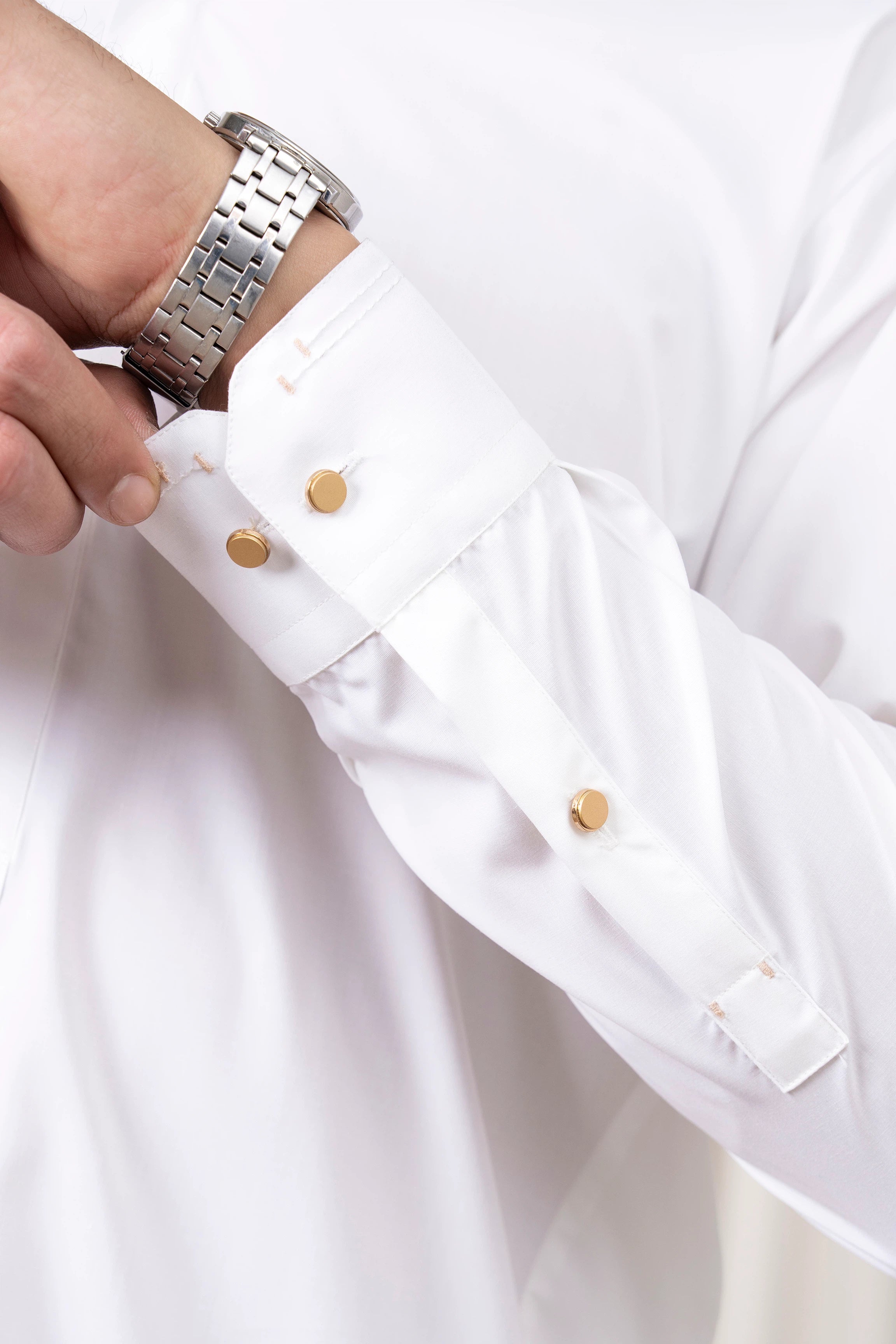 White kameez sleeve cuff with gold-tone buttons and stitched trim