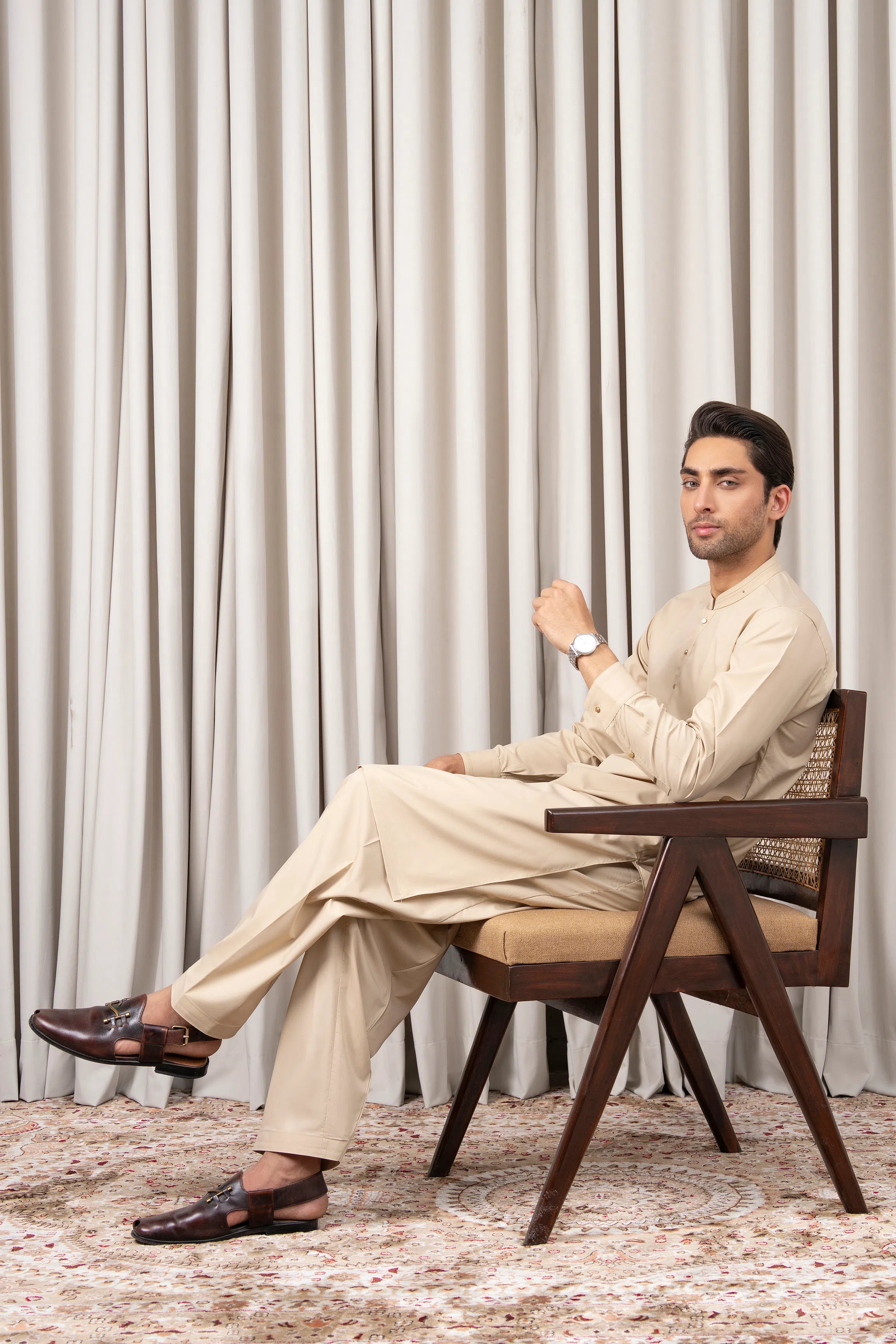Beige kurta kameez and shalwar set, seated pose with long sleeves and buttons