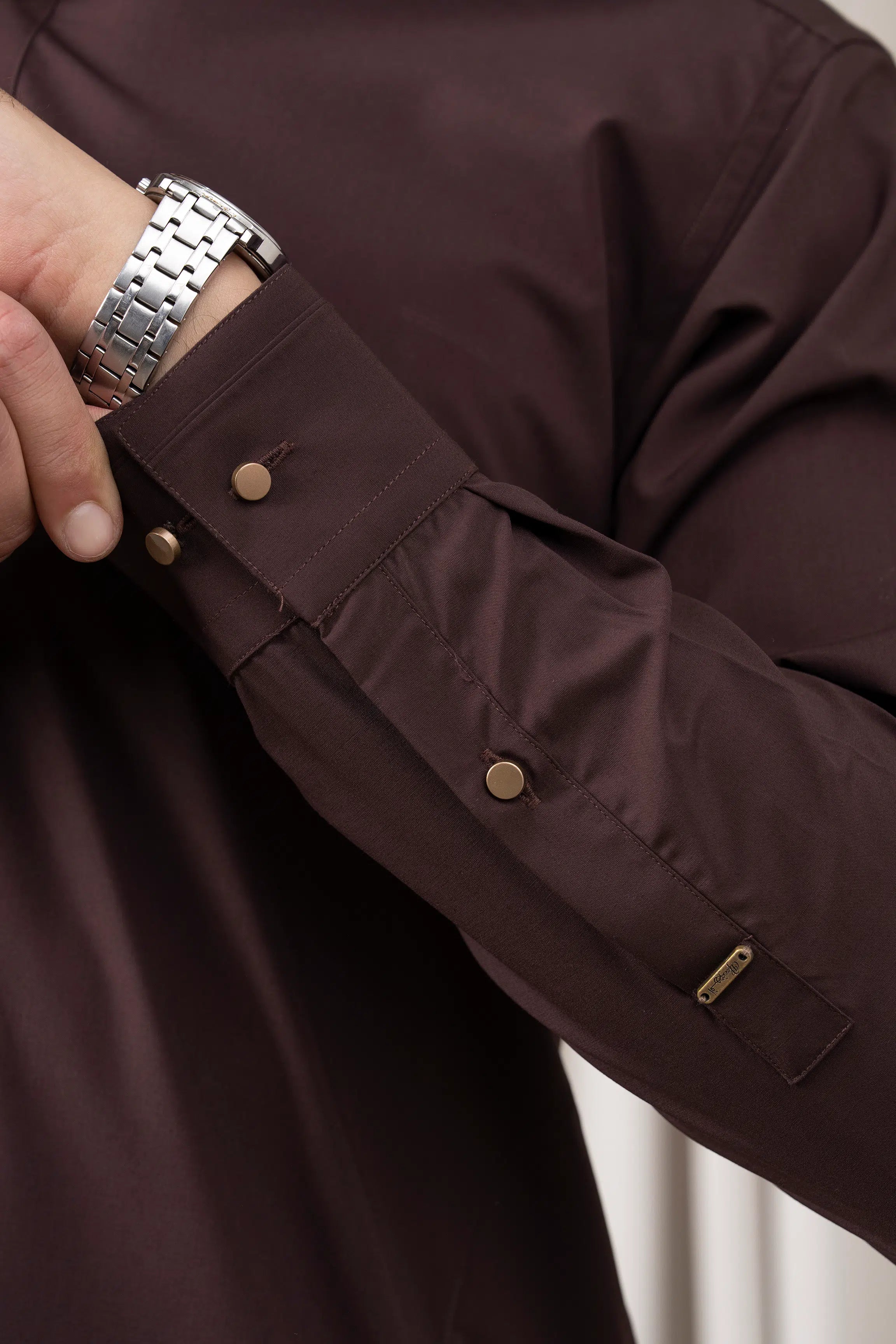 Dark brown kurta sleeve cuff with buttoned placket and pocket detail