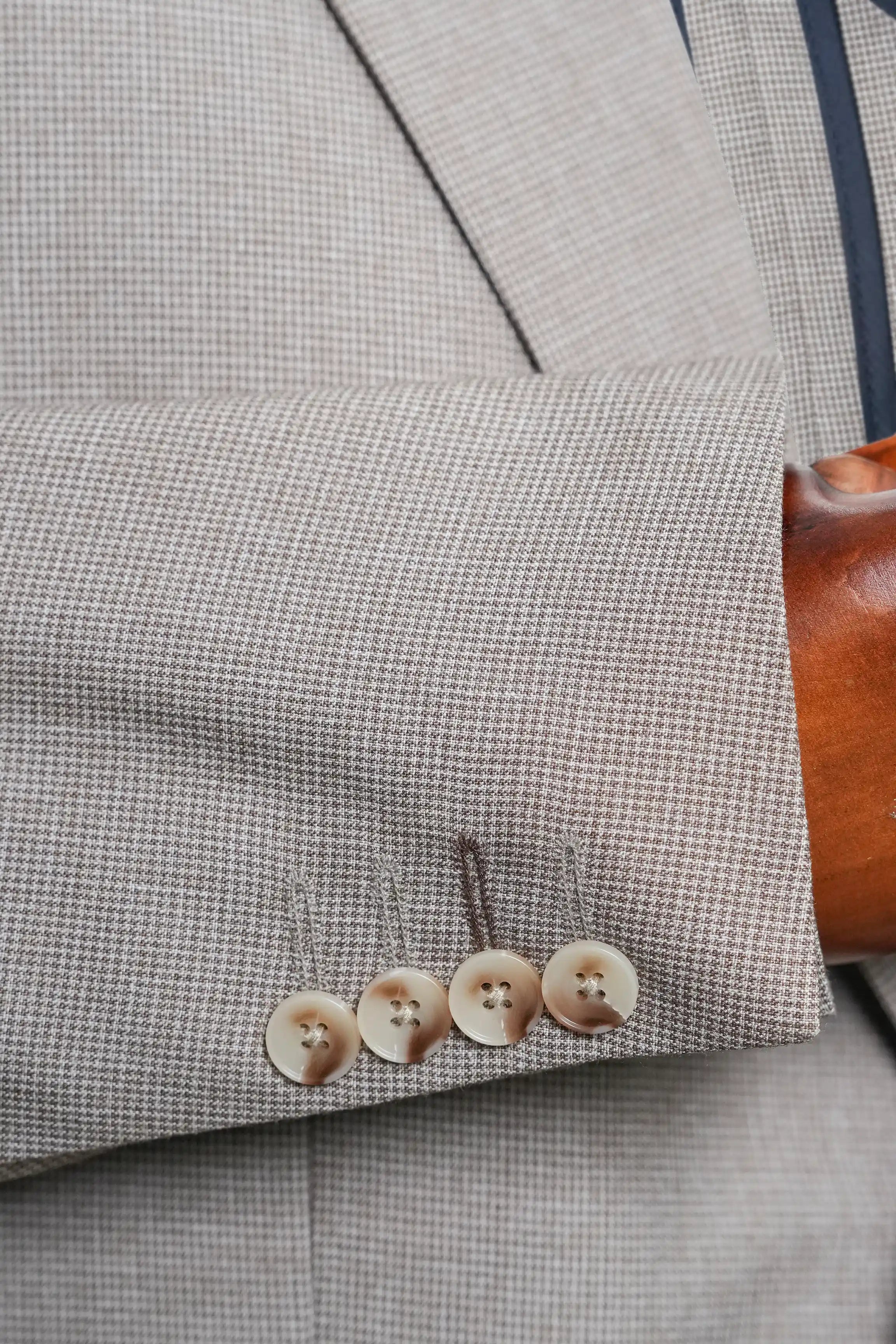 Khaki check coat detail with sleeve vent and four matching buttons