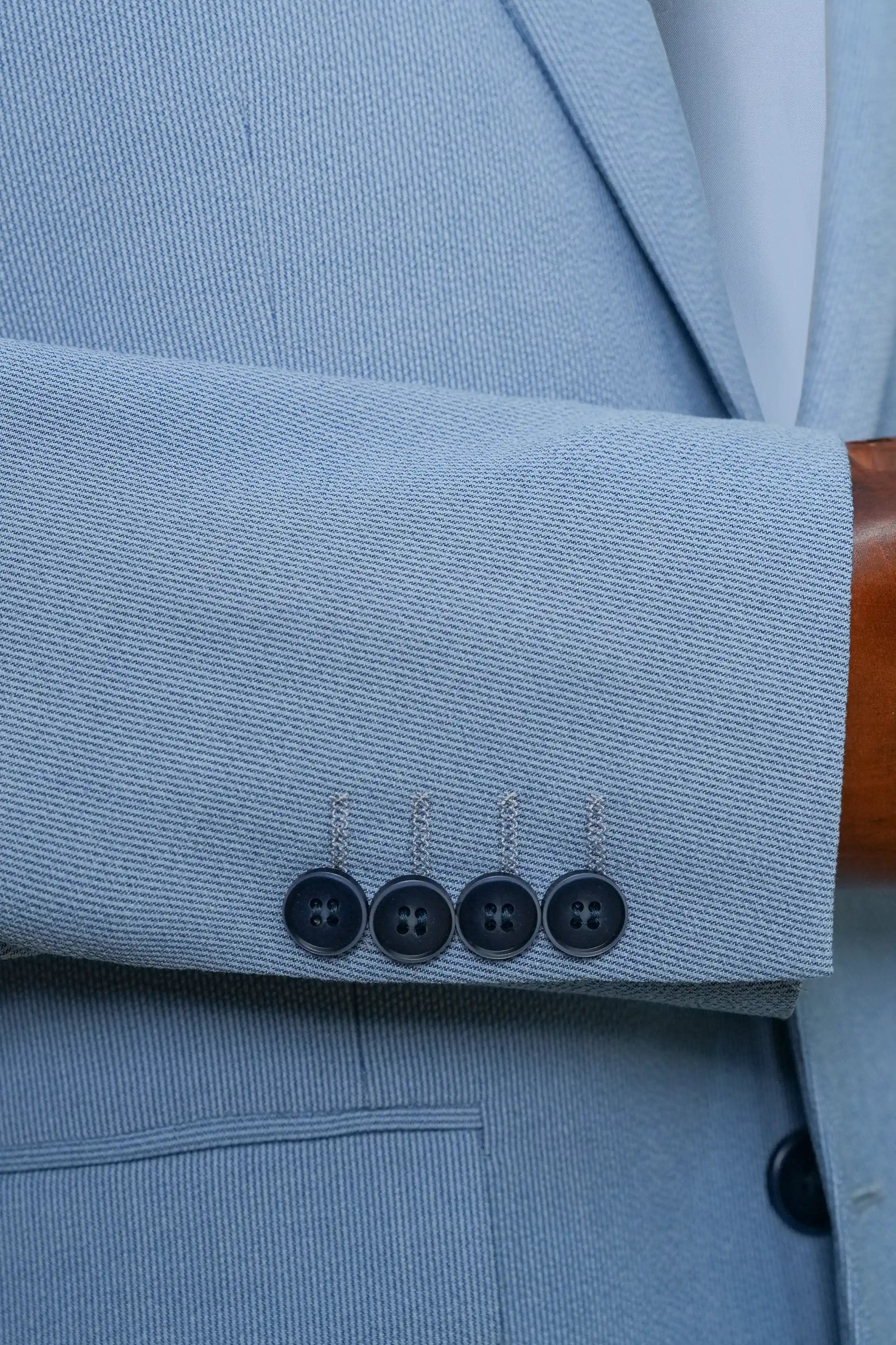 Sky blue coat sleeve cuff with four-button detail