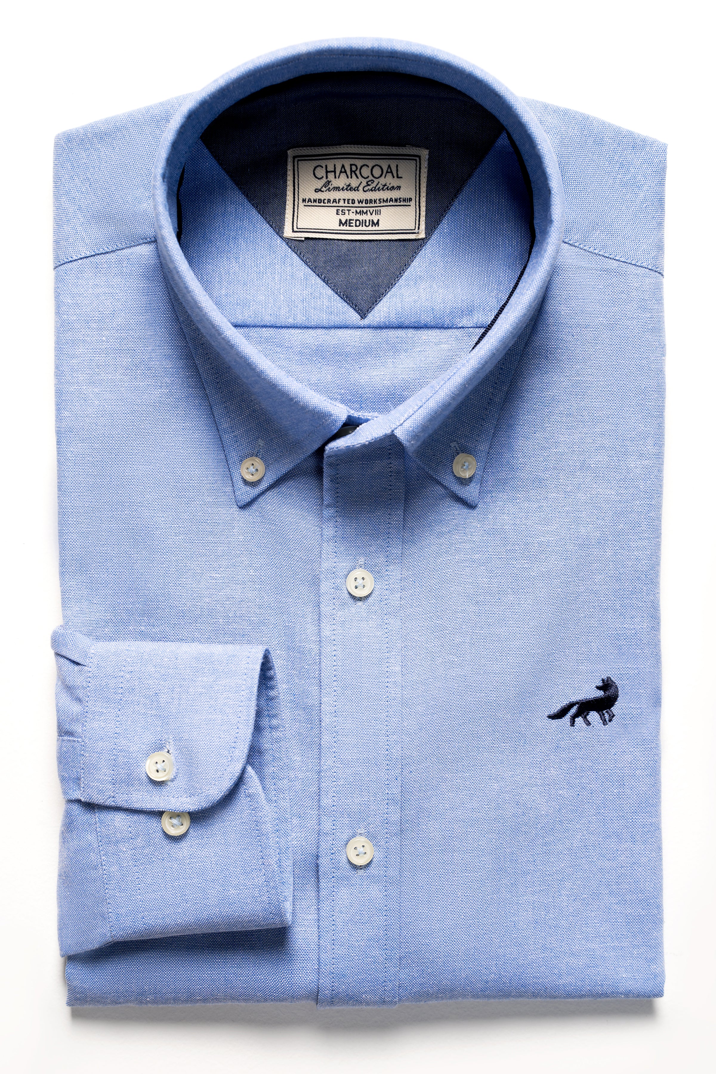 Light blue button-up shirt with pointed collar and small black animal logo
