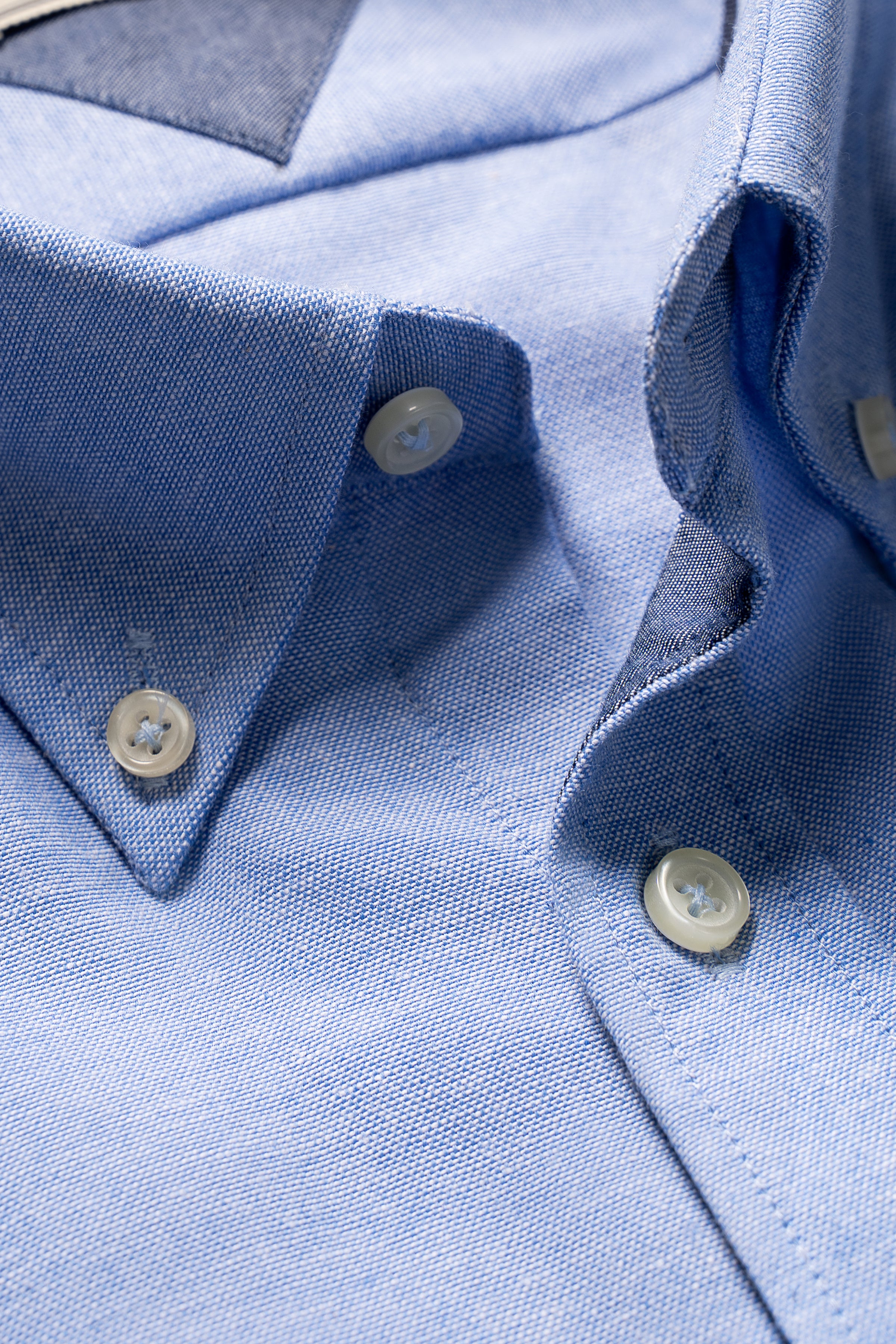 Light blue shirt collar and button placket with white buttons